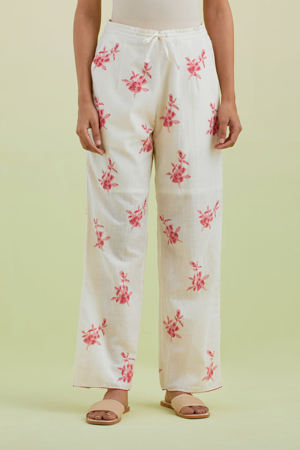 Off white straight pants with all-over pink colored floral boota hand-block print.