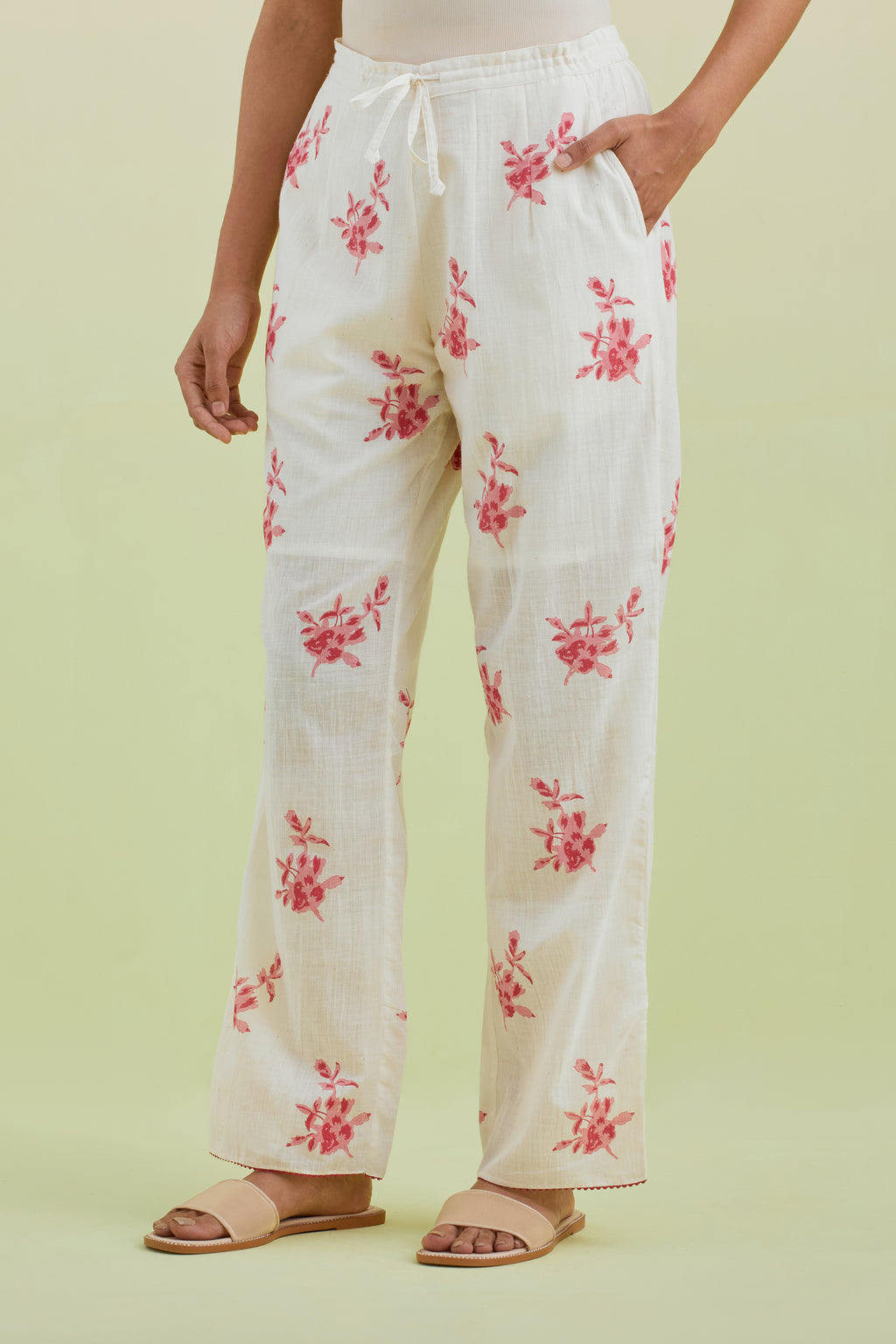 Off white straight pants with all-over pink colored floral boota hand-block print.