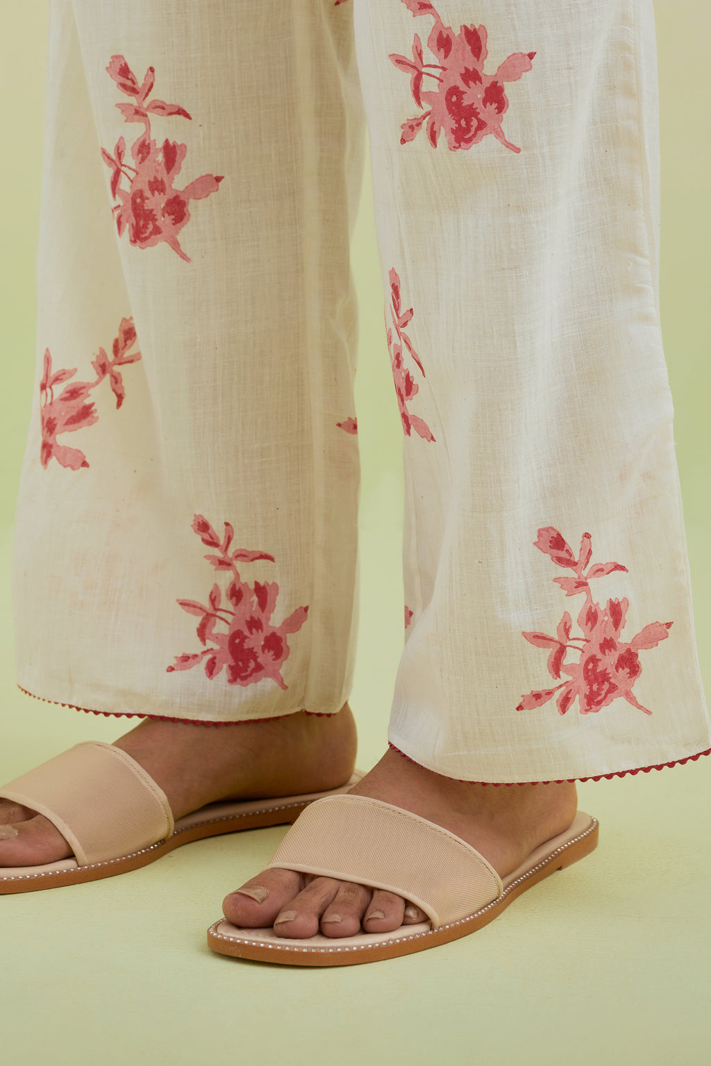 Off white straight pants with all-over pink colored floral boota hand-block print.