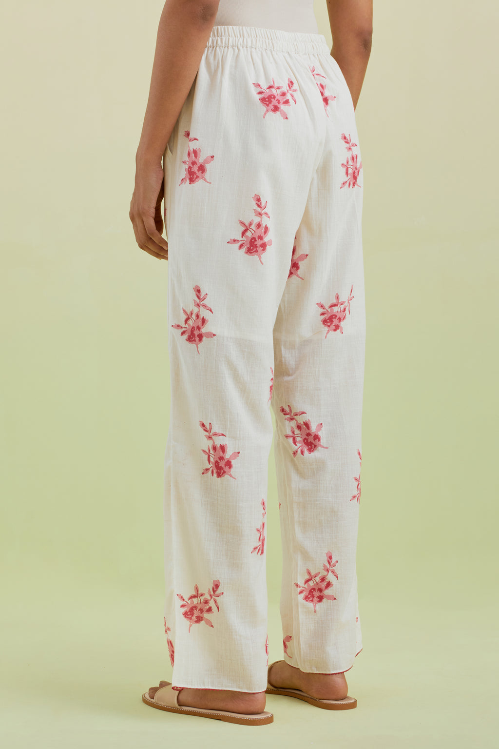 Off white straight pants with all-over pink colored floral boota hand-block print.