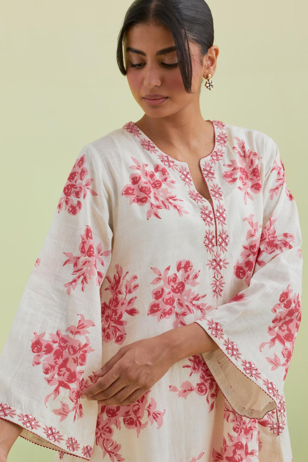 Pink and off-white cotton hand-block printed A-line short kurta set with round neck and asymmetric hem.