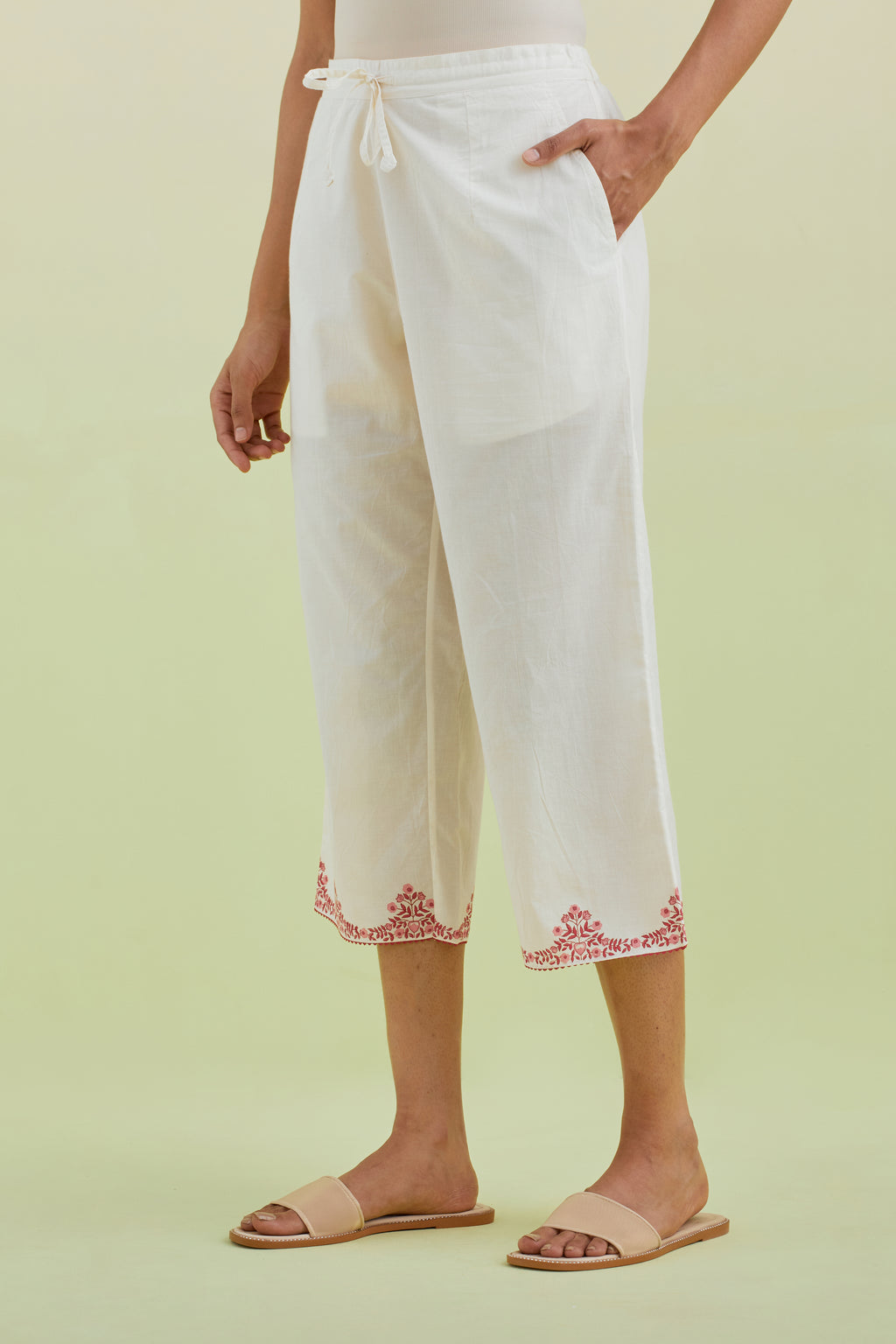 Off white straight ankle length pants with pink colored hand-block printed border at hem.