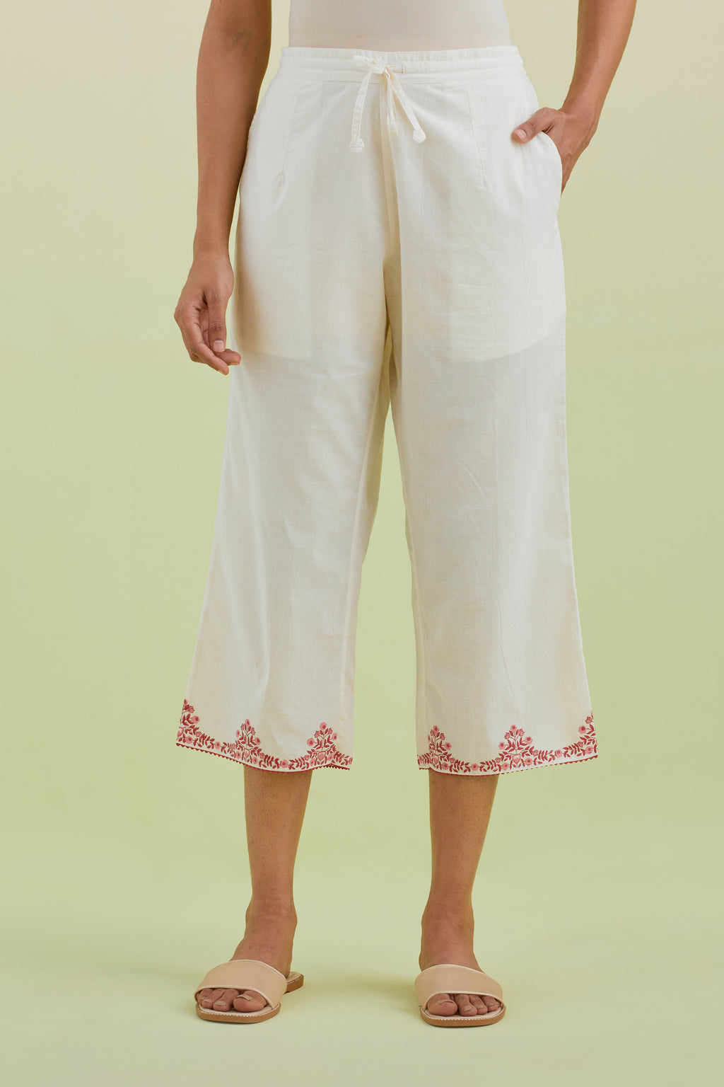 Off white straight ankle length pants with pink colored hand-block printed border at hem.