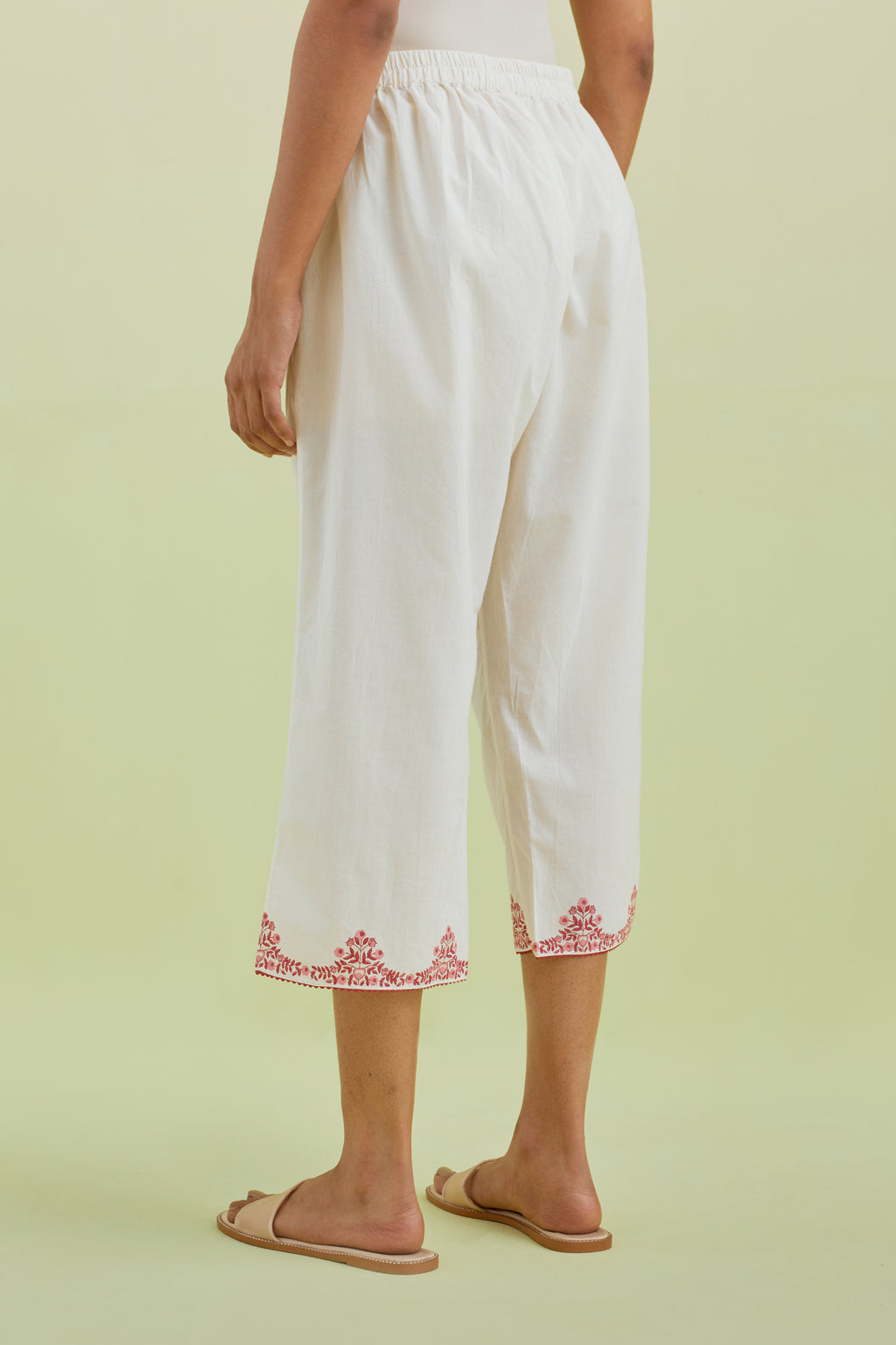 Off white straight ankle length pants with pink colored hand-block printed border at hem.