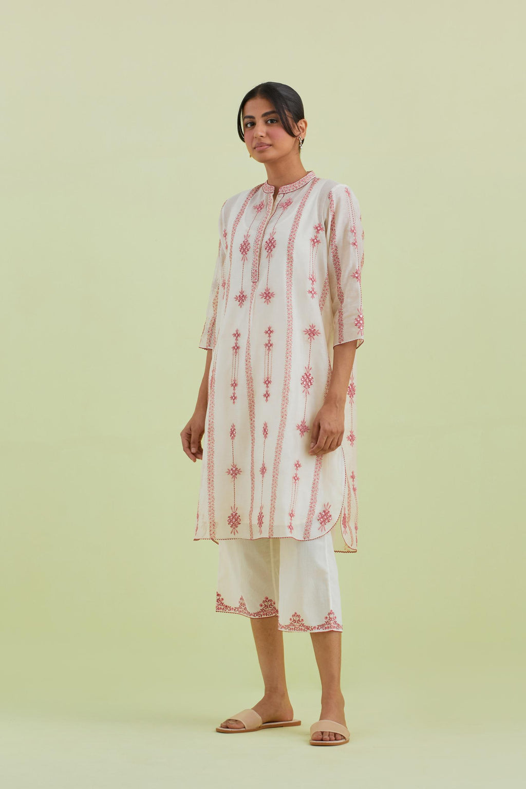 Pink and off-white hand block printed silk chanderi straight short kurta with thread and mirror embroidery along with kantha work, paired with off white straight ankle length pants with pink colored hand-block printed border at hem.