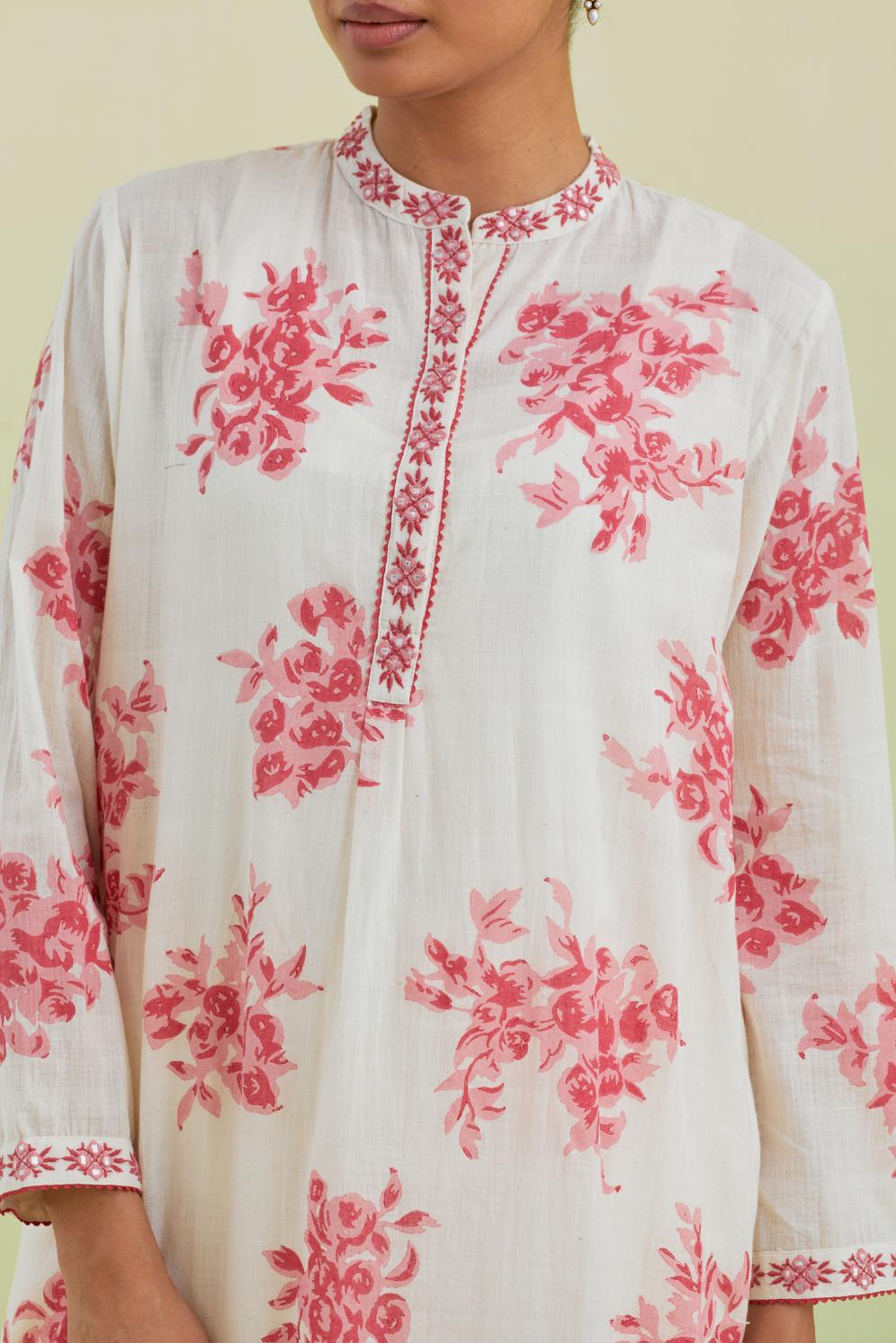 Pink and off-white cotton straight short kurta with all-over hand block print and embroidery at neck and sleeves, paired with off white straight ankle length pants with all-over pink colored floral boota hand-block print.