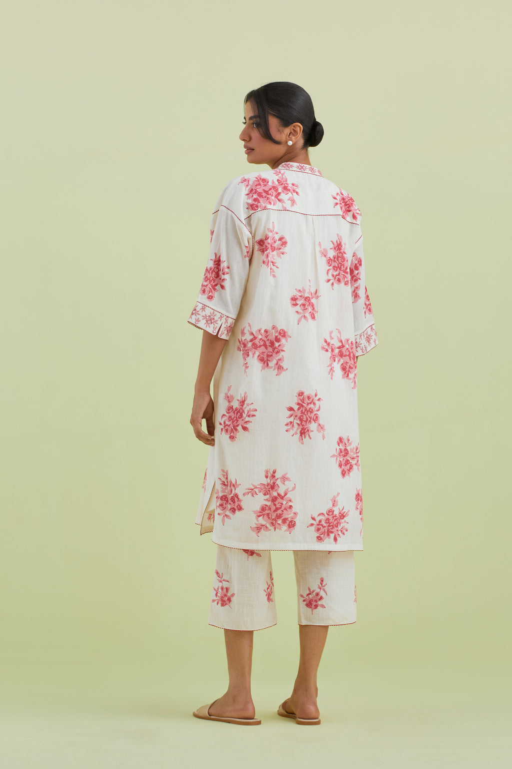 Pink and off-white hand block printed cotton easy fit short kurta with thread and mirror embroidery, paired with off white straight ankle length pants with all-over pink colored floral boota hand-block print.