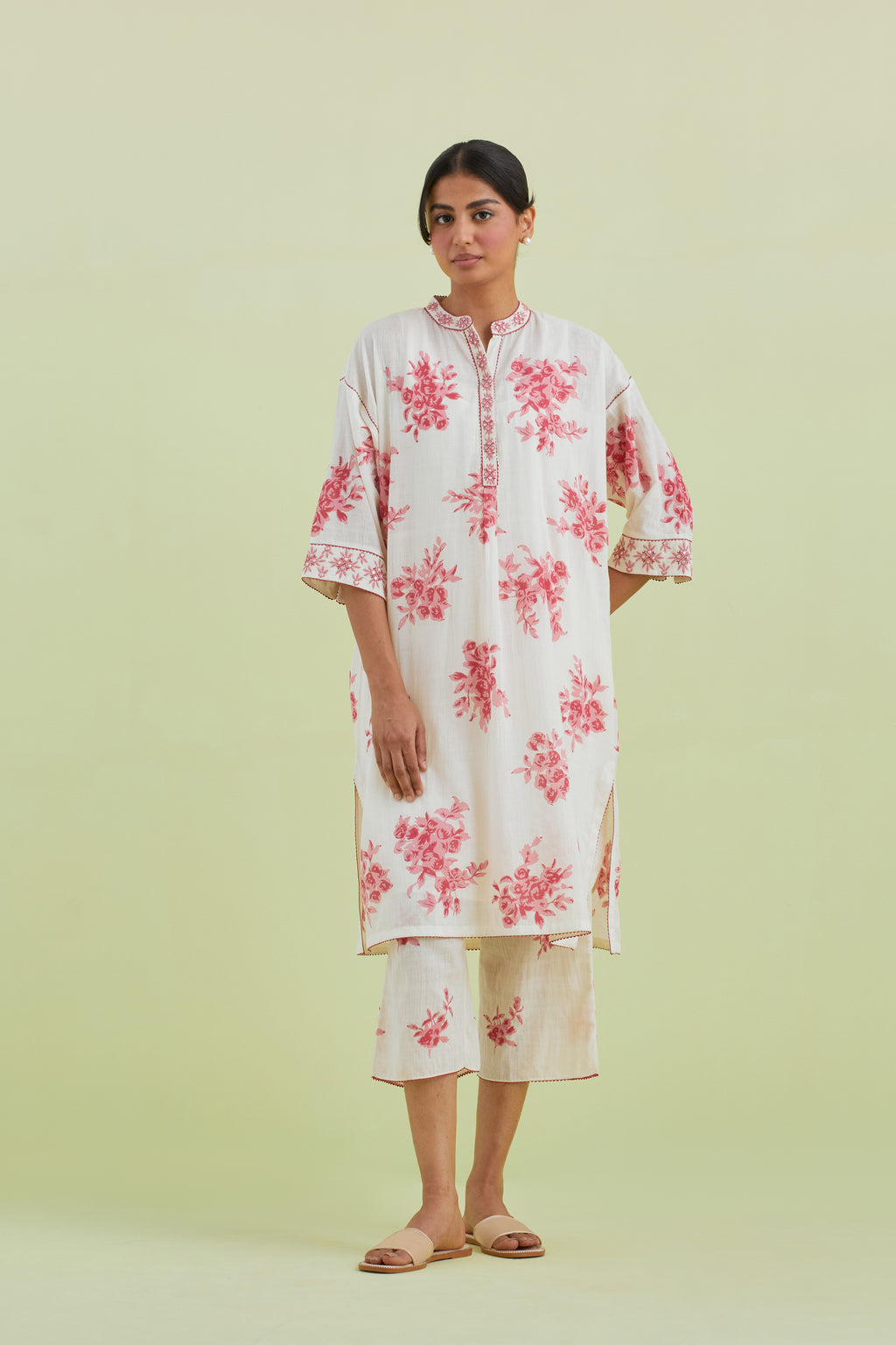 Pink and off-white hand block printed cotton easy fit short kurta with thread and mirror embroidery, paired with off white straight ankle length pants with all-over pink colored floral boota hand-block print.