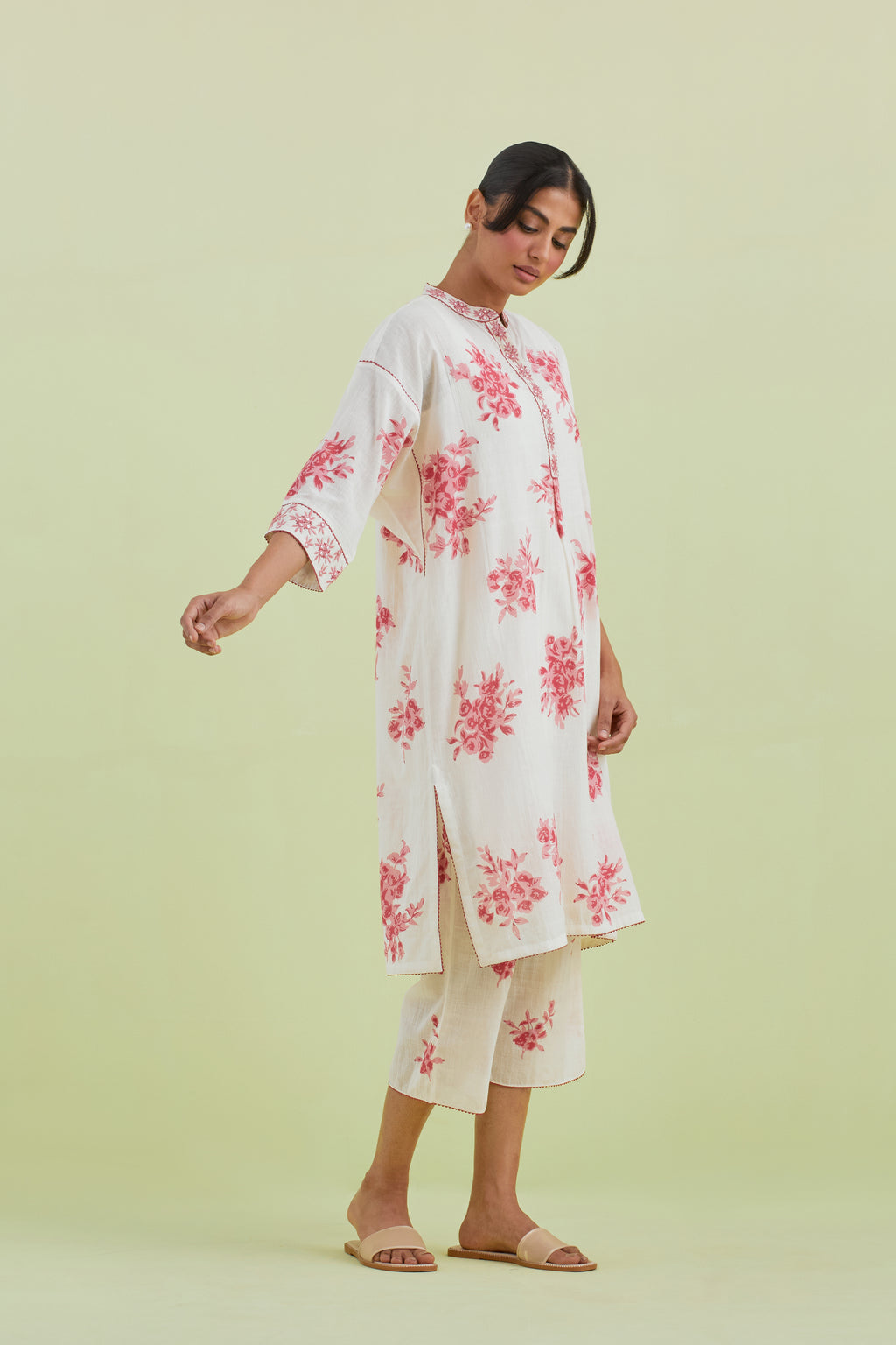 Pink and off-white hand block printed cotton easy fit short kurta with thread and mirror embroidery, paired with off white straight ankle length pants with all-over pink colored floral boota hand-block print.