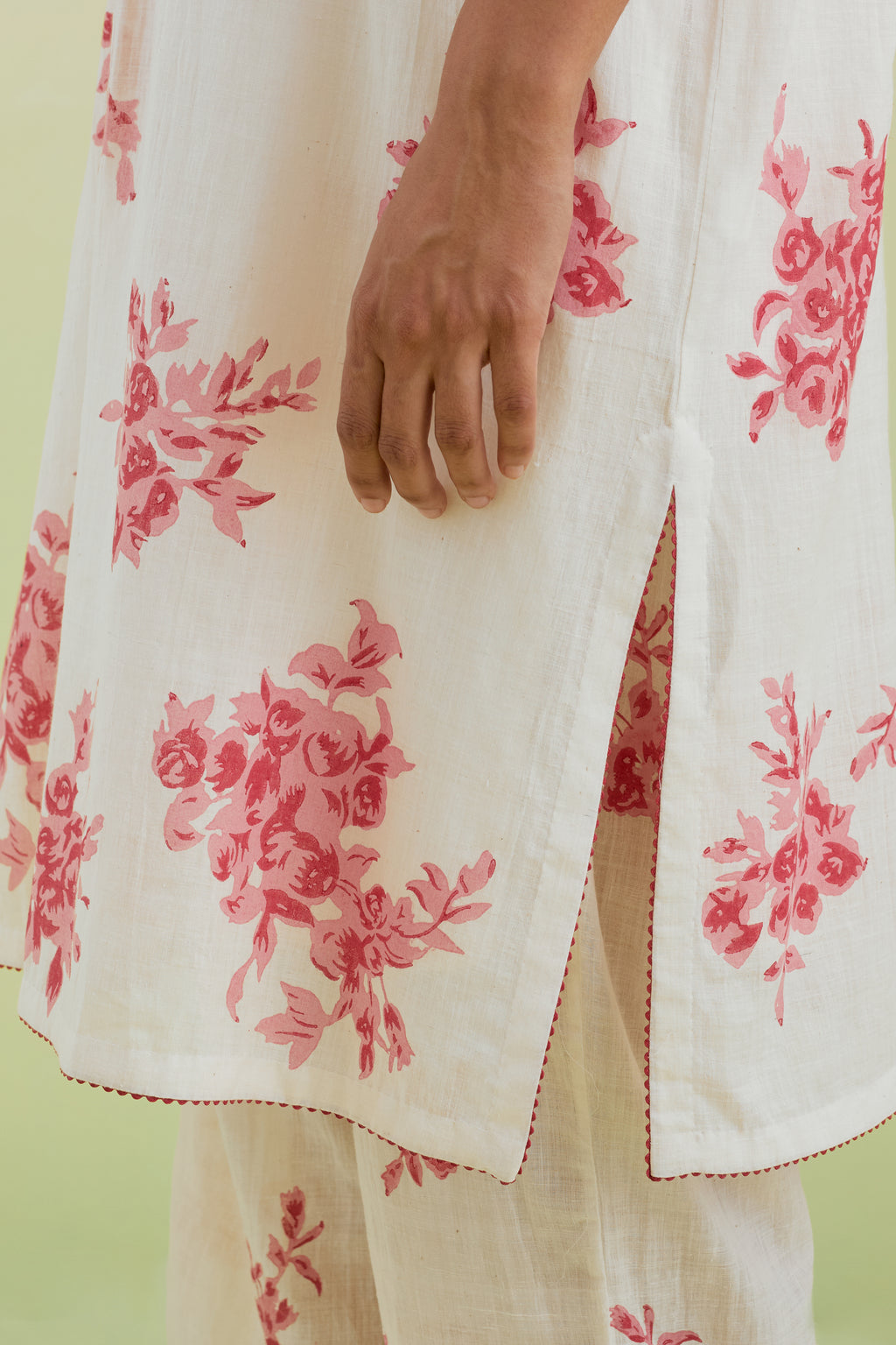 Pink and off-white hand block printed cotton easy fit short kurta with thread and mirror embroidery, paired with off white straight ankle length pants with all-over pink colored floral boota hand-block print.