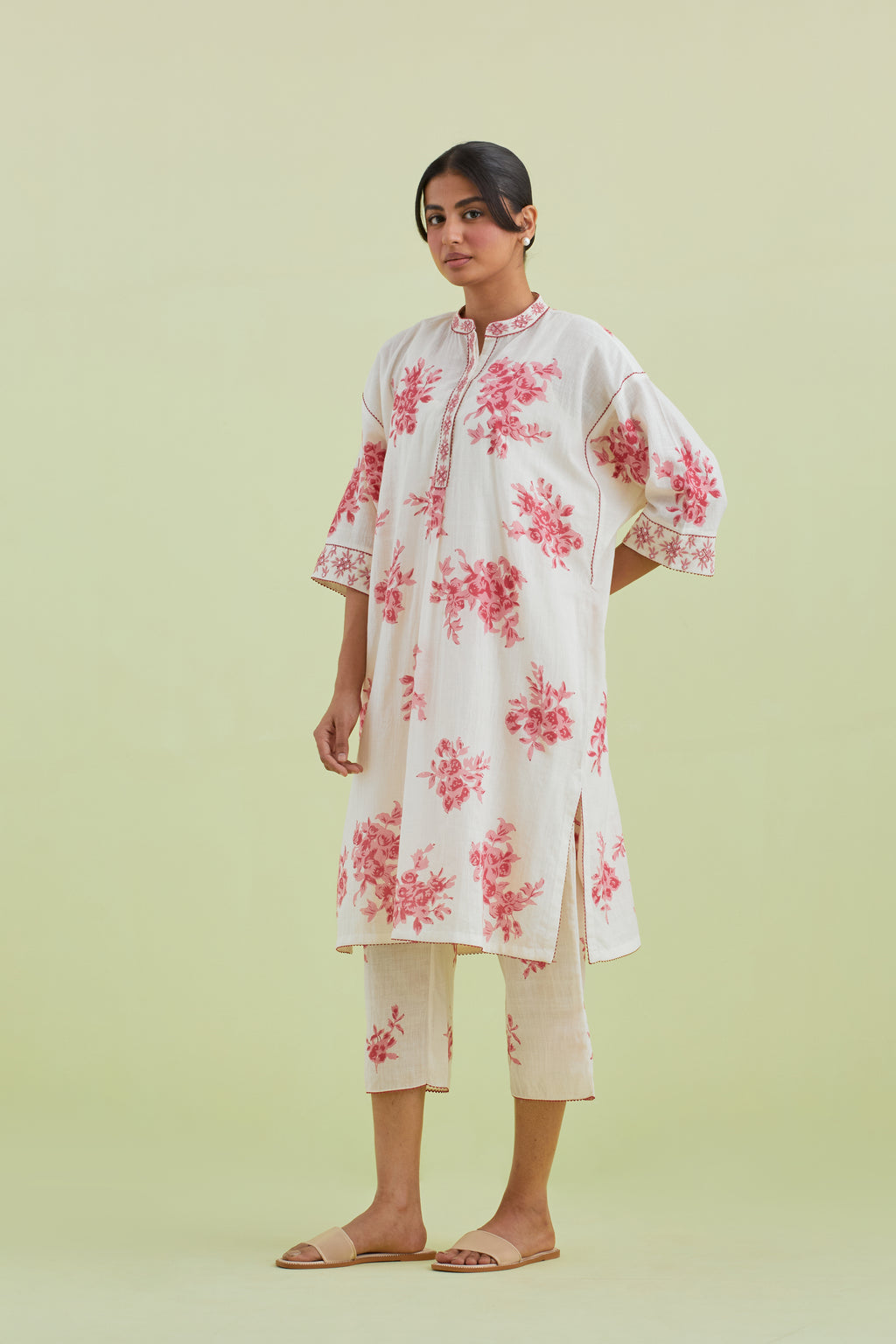 Pink and off-white hand block printed cotton easy fit short kurta with thread and mirror embroidery, paired with off white straight ankle length pants with all-over pink colored floral boota hand-block print.