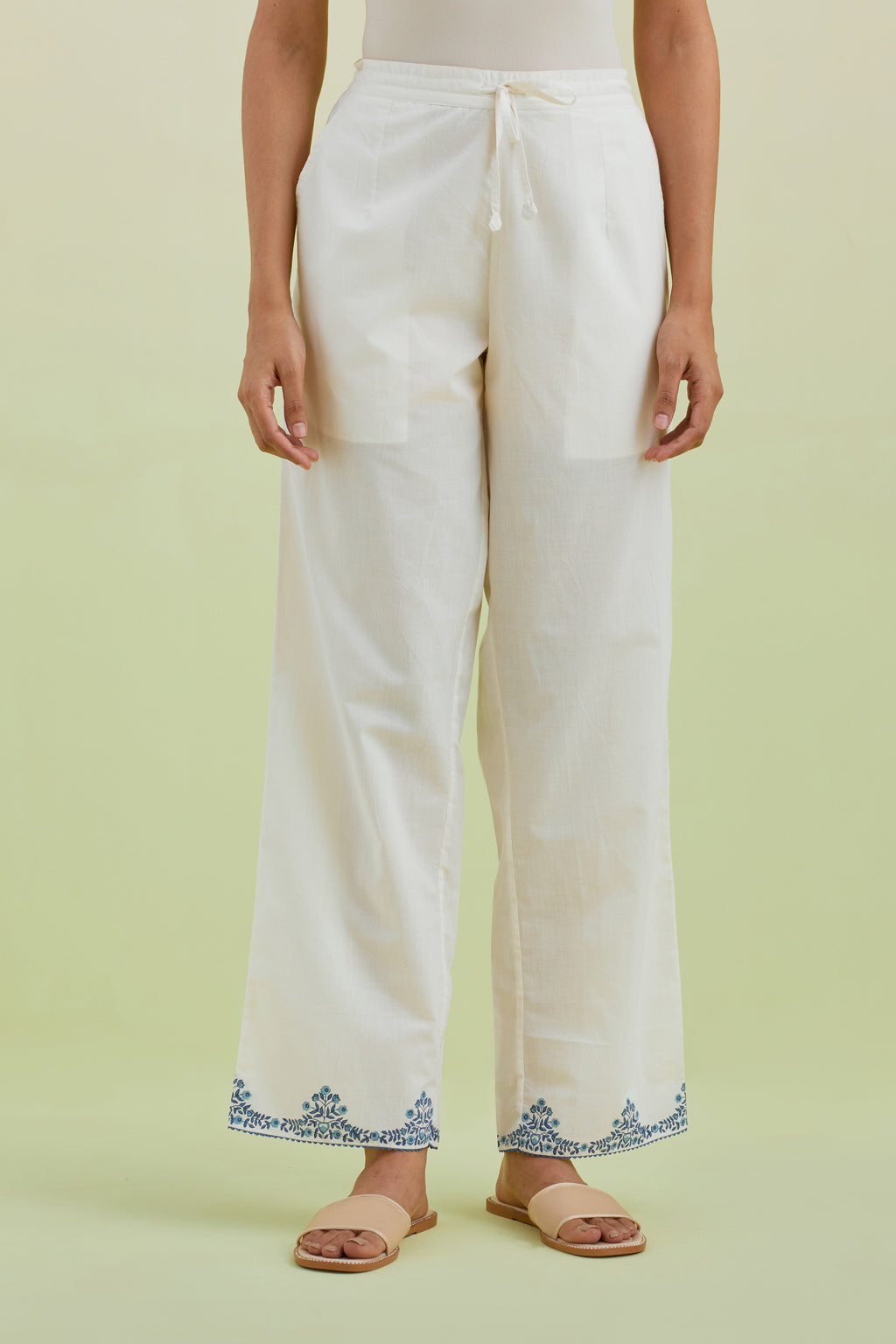 Off white straight pants with blue colored hand-block printed border at hem.