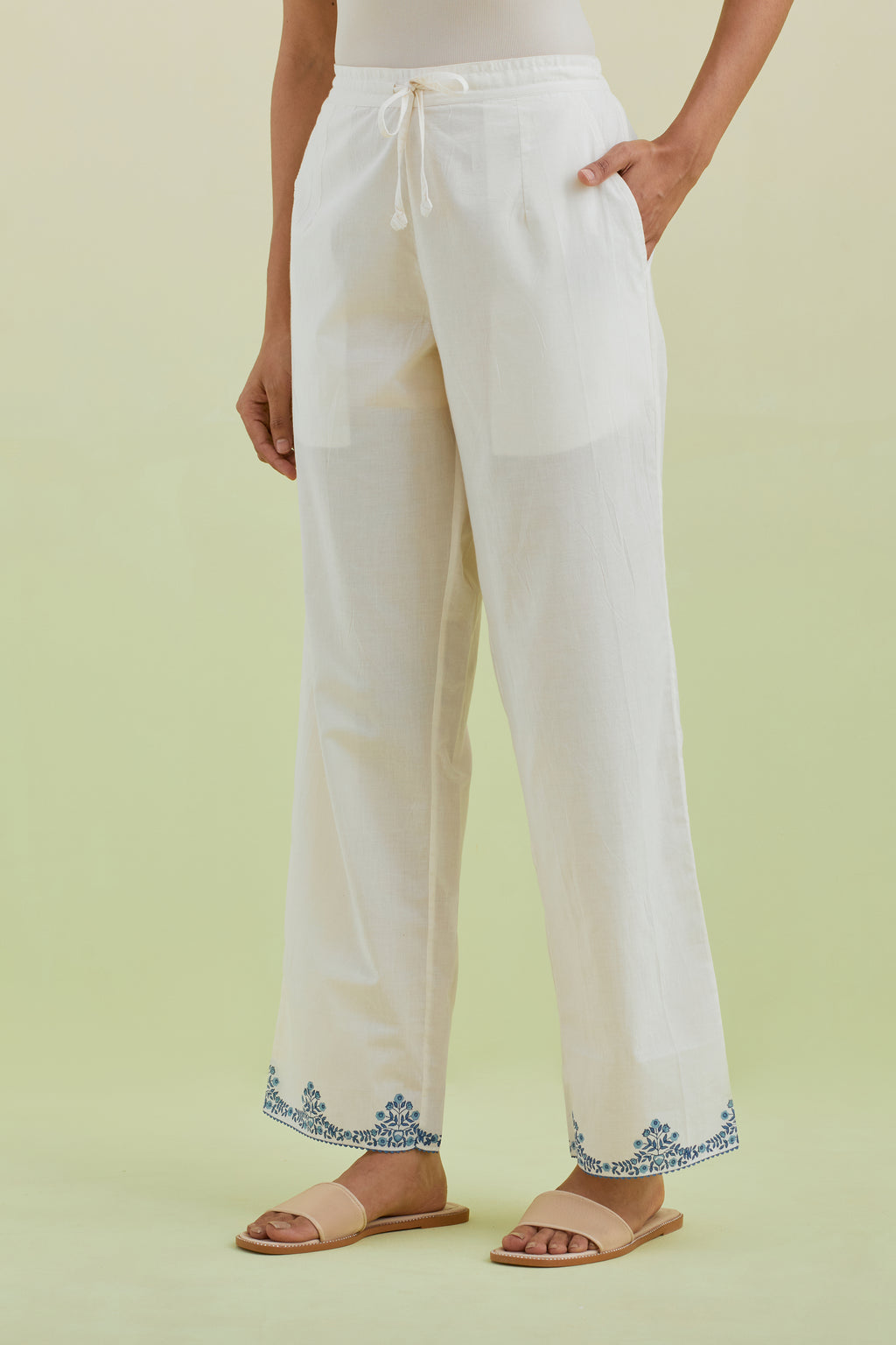 Off white straight pants with blue colored hand-block printed border at hem.