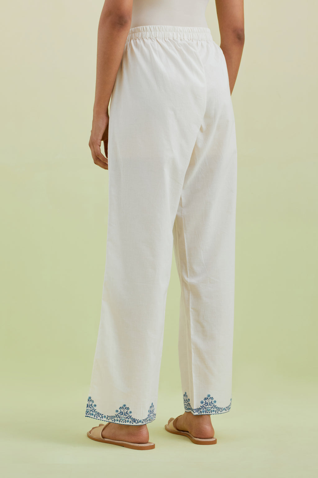 Off white straight pants with blue colored hand-block printed border at hem.