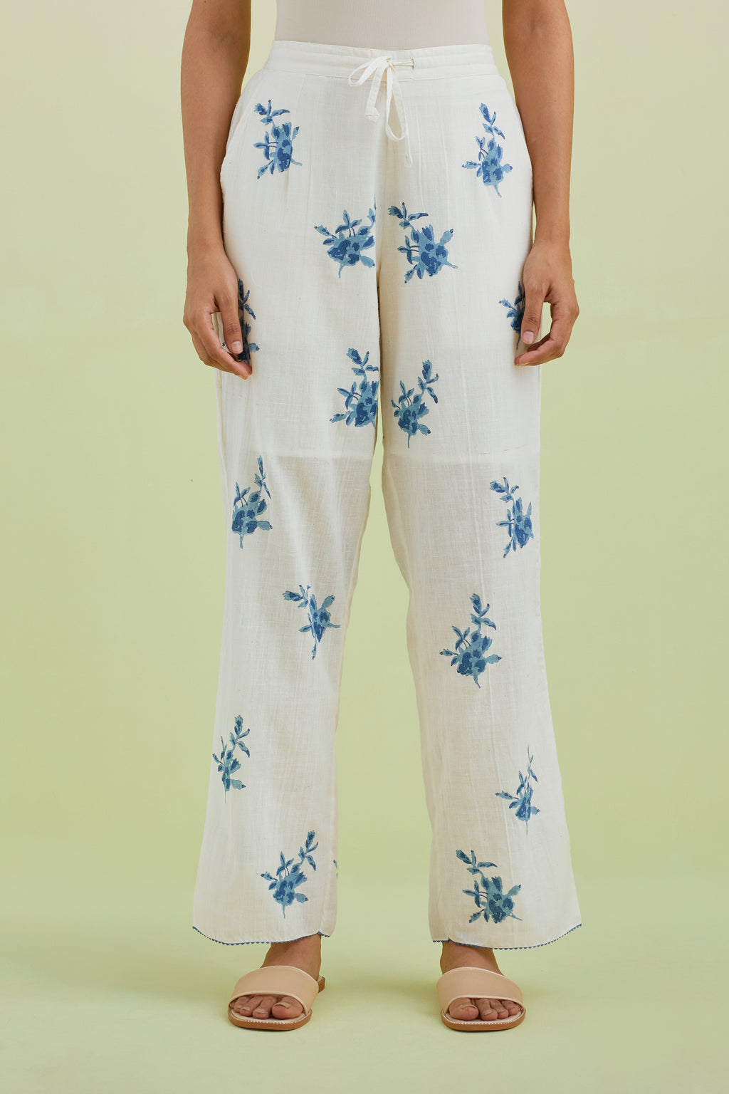 Off white straight pants with all-over blue colored floral boota hand-block print.