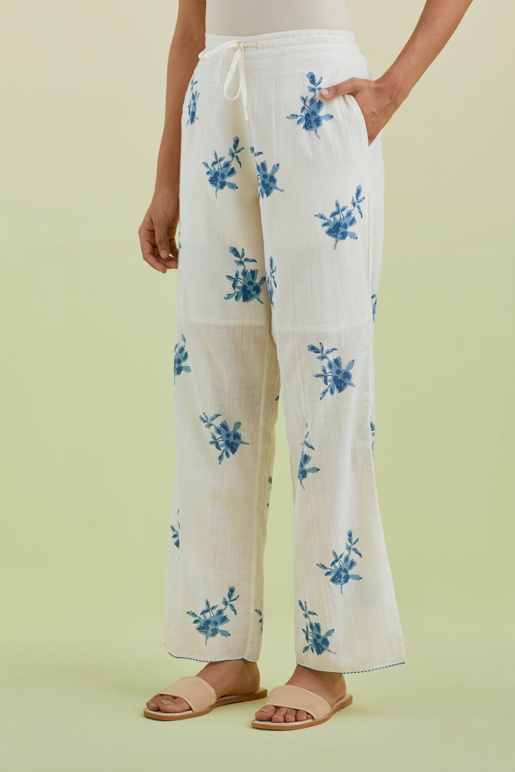 Off white straight pants with all-over blue colored floral boota hand-block print.