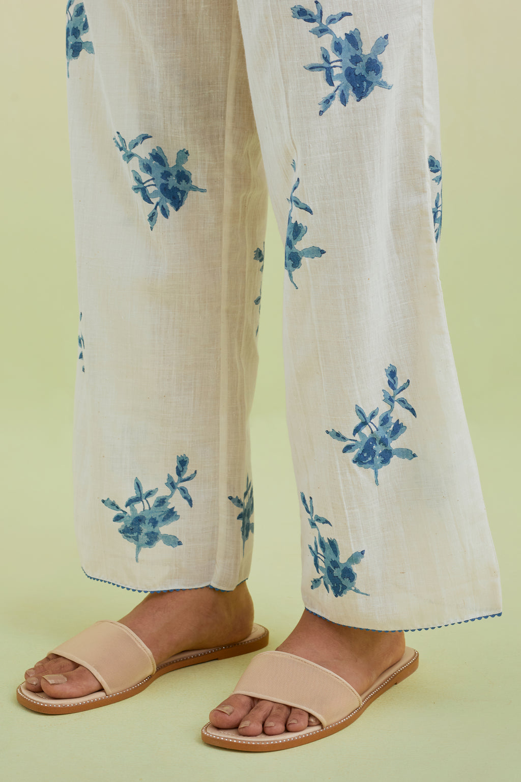 Off white straight pants with all-over blue colored floral boota hand-block print.