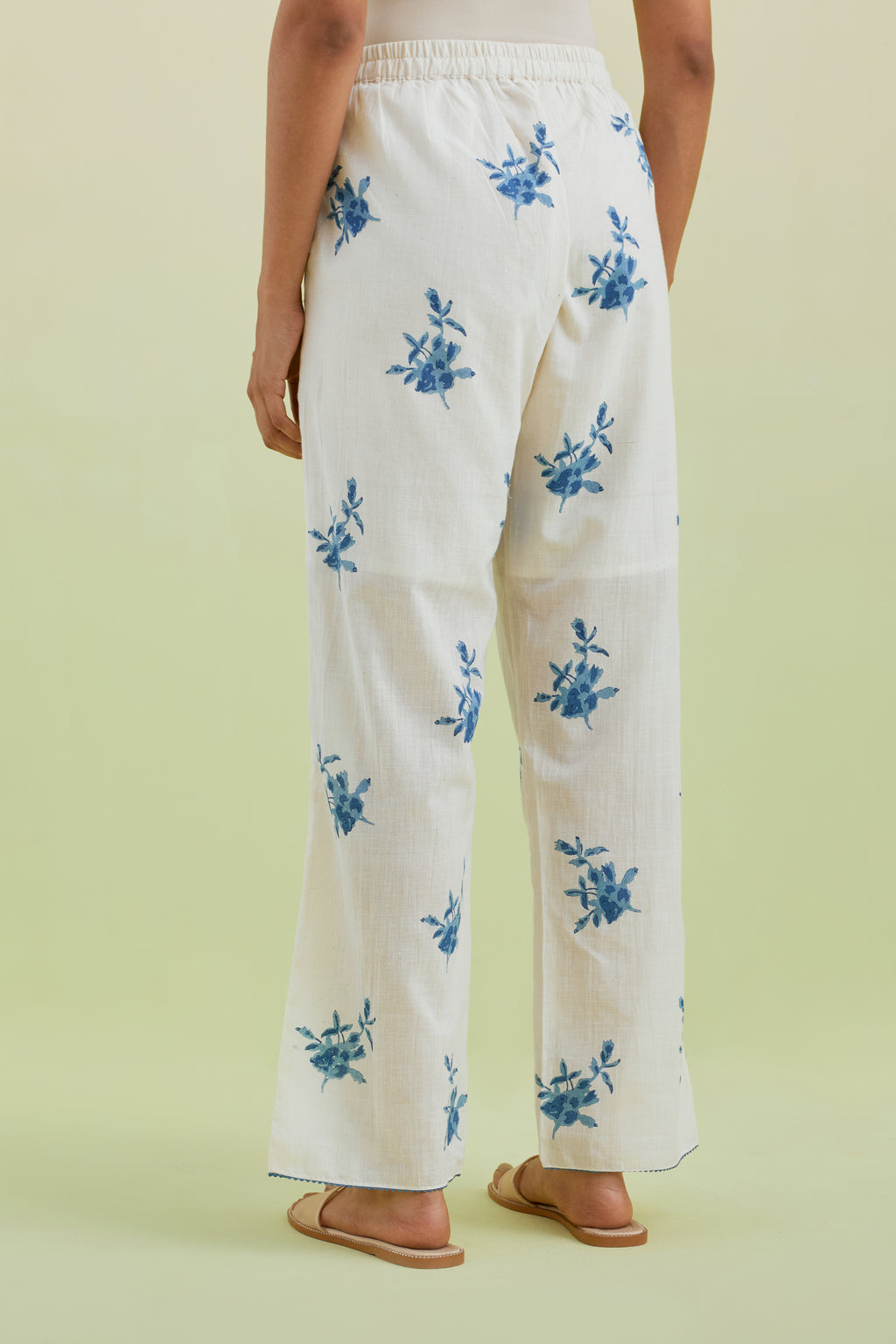 Off white straight pants with all-over blue colored floral boota hand-block print.