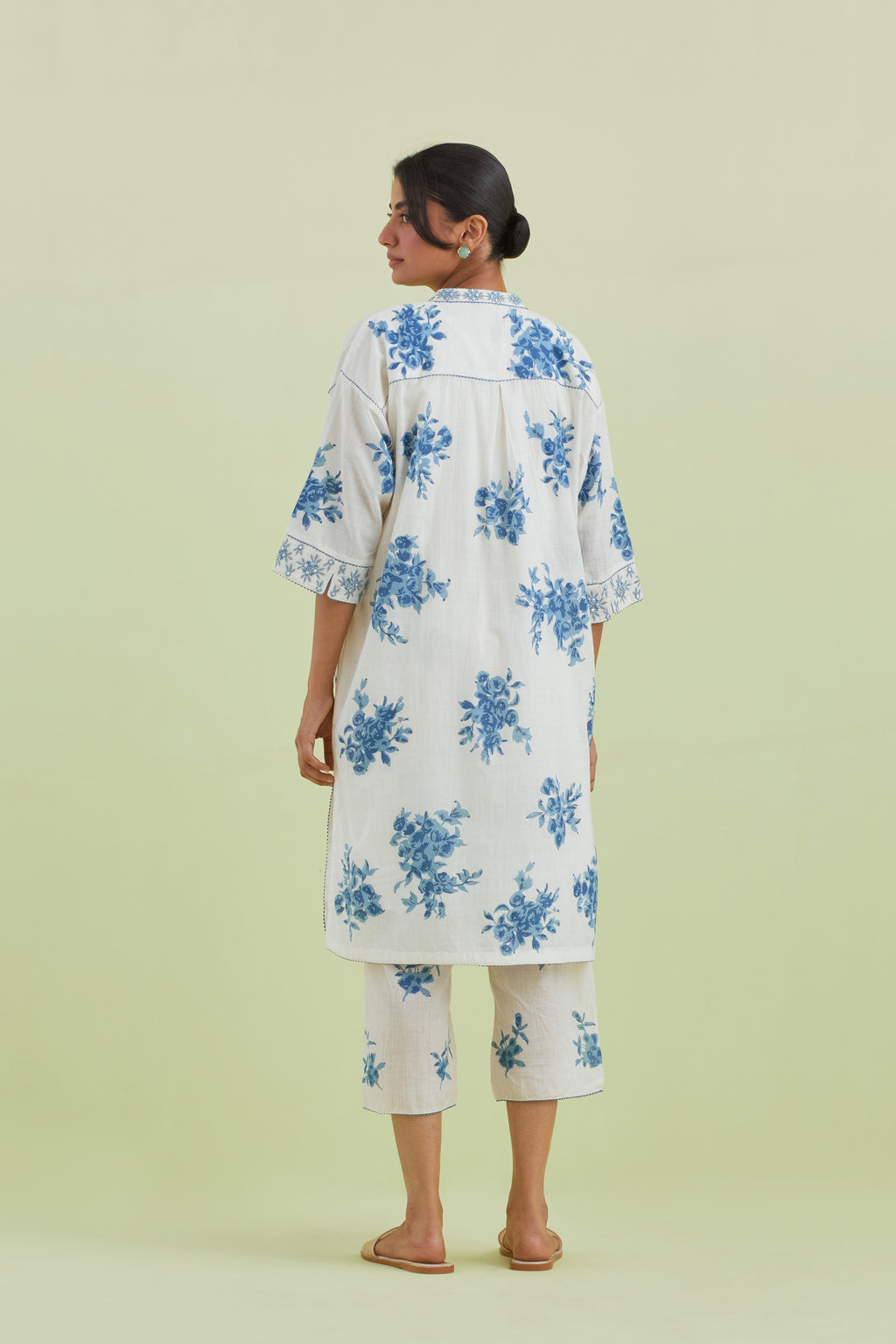 Blue and off-white hand block printed cotton easy fit short kurta with thread and mirror embroidery, paired with off white straight ankle length pants with all-over blue colored floral boota hand-block print.