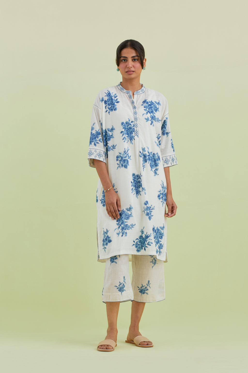 Blue and off-white hand block printed cotton easy fit short kurta with thread and mirror embroidery, paired with off white straight ankle length pants with all-over blue colored floral boota hand-block print.