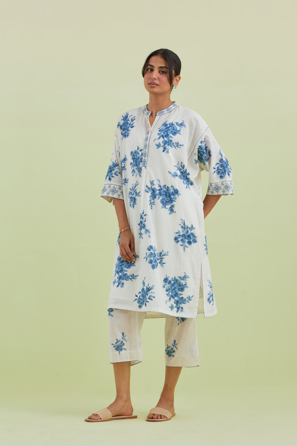 Blue and off-white hand block printed cotton easy fit short kurta with thread and mirror embroidery, paired with off white straight ankle length pants with all-over blue colored floral boota hand-block print.