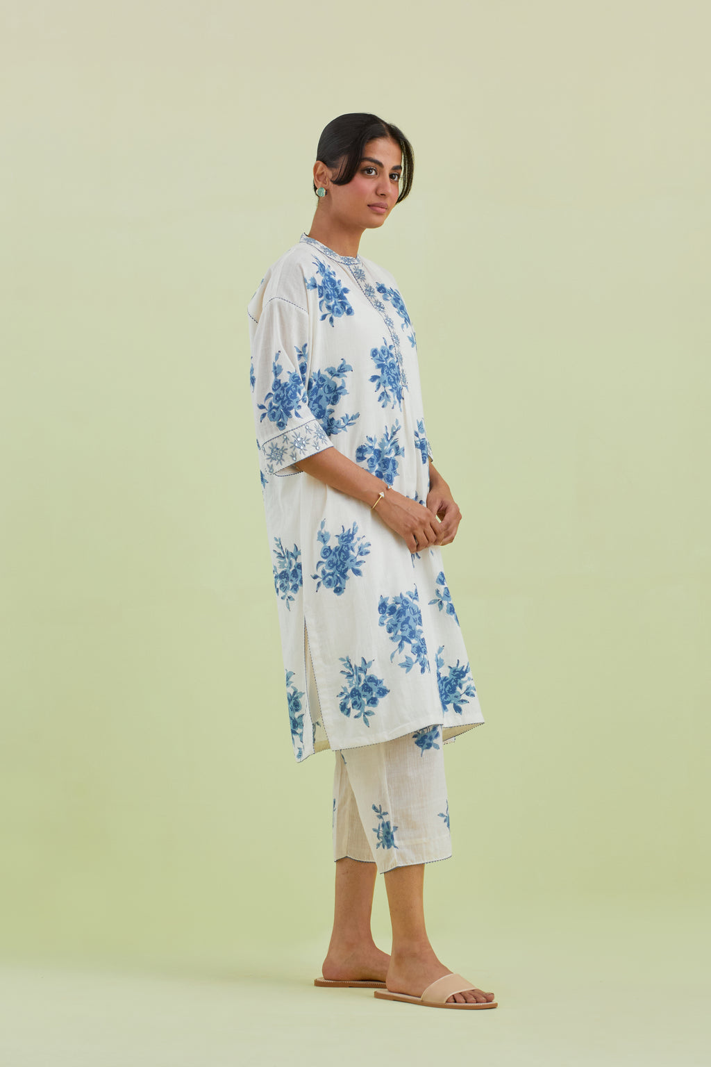 Blue and off-white hand block printed cotton easy fit short kurta with thread and mirror embroidery, paired with off white straight ankle length pants with all-over blue colored floral boota hand-block print.