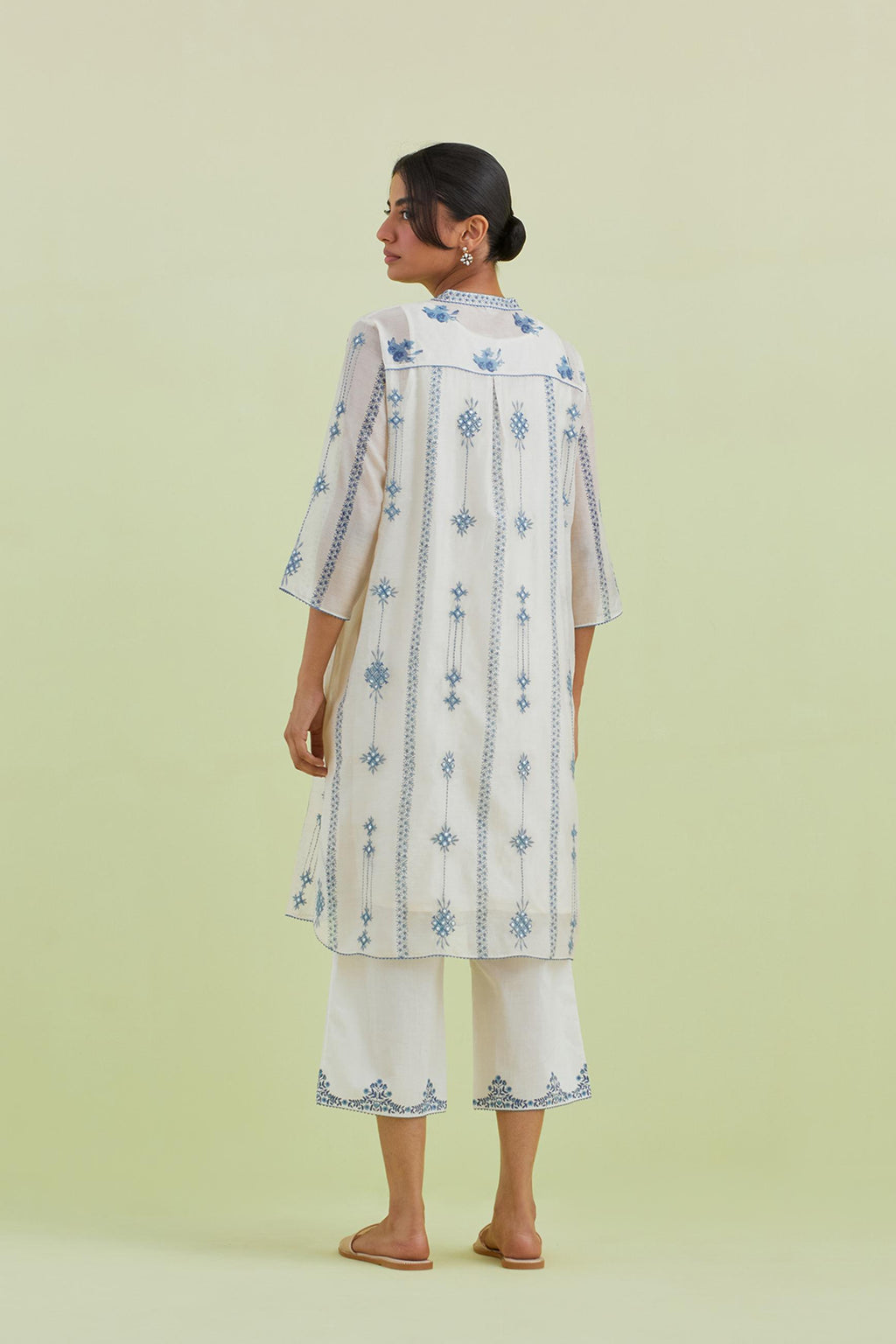 Blue and off-white hand block printed silk chanderi straight short kurta with thread and mirror embroidery along with kantha work, paired with off white straight ankle length pants with blue colored hand-block printed border at hem.