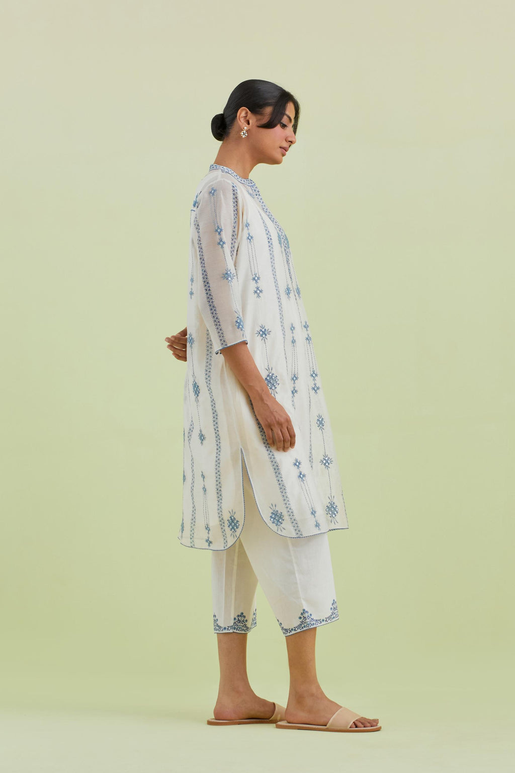 Blue and off-white hand block printed silk chanderi straight short kurta with thread and mirror embroidery along with kantha work, paired with off white straight ankle length pants with blue colored hand-block printed border at hem.