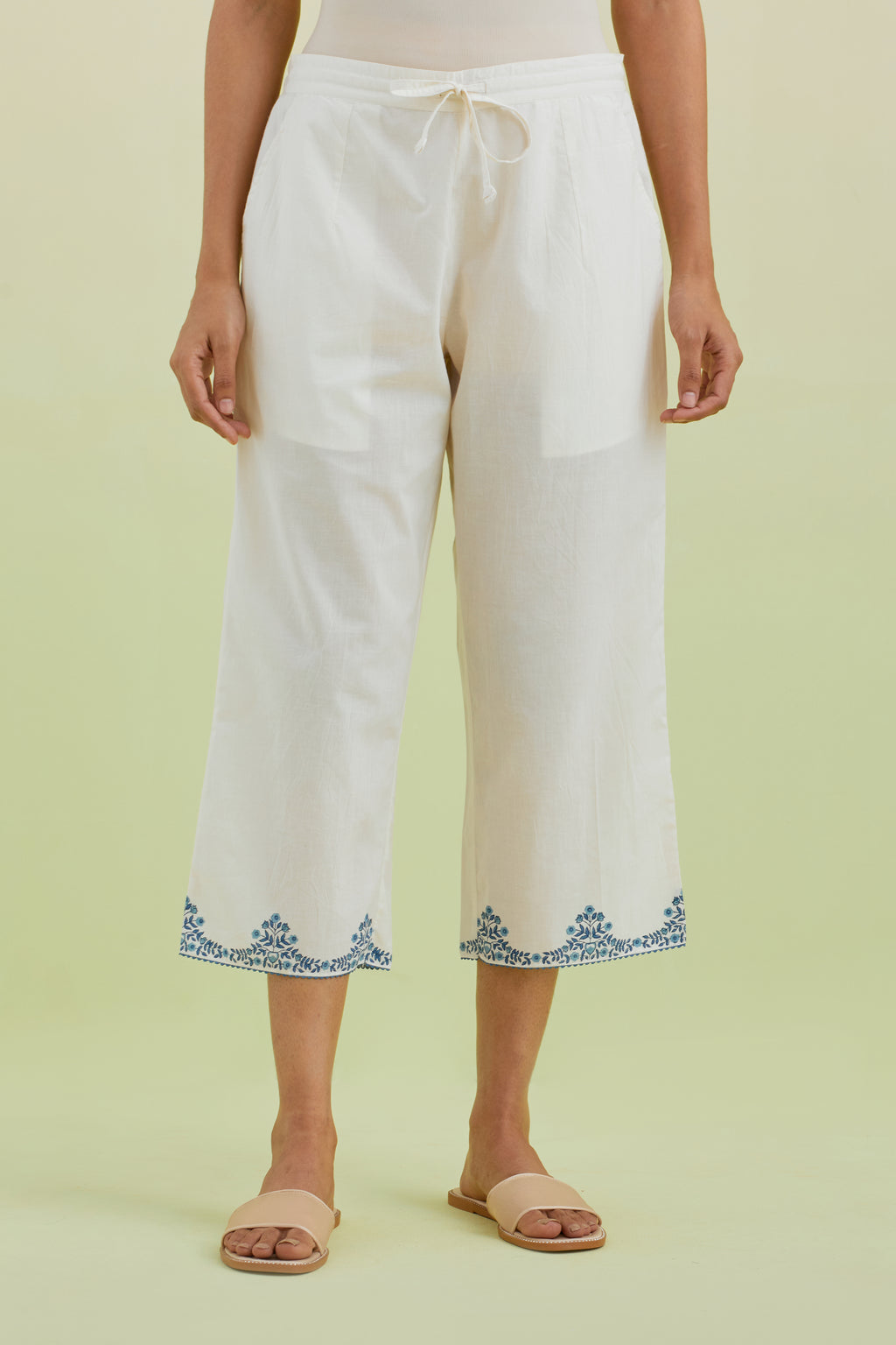 Off white straight ankle length pants with blue colored hand-block printed border at hem.