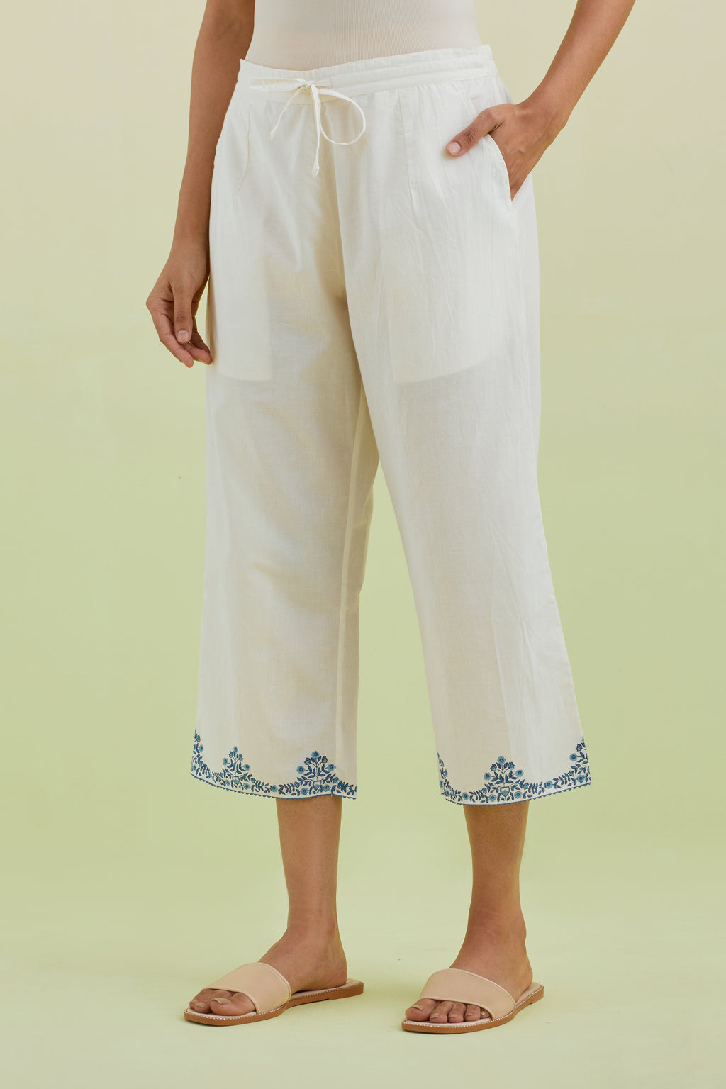 Off white straight ankle length pants with blue colored hand-block printed border at hem.