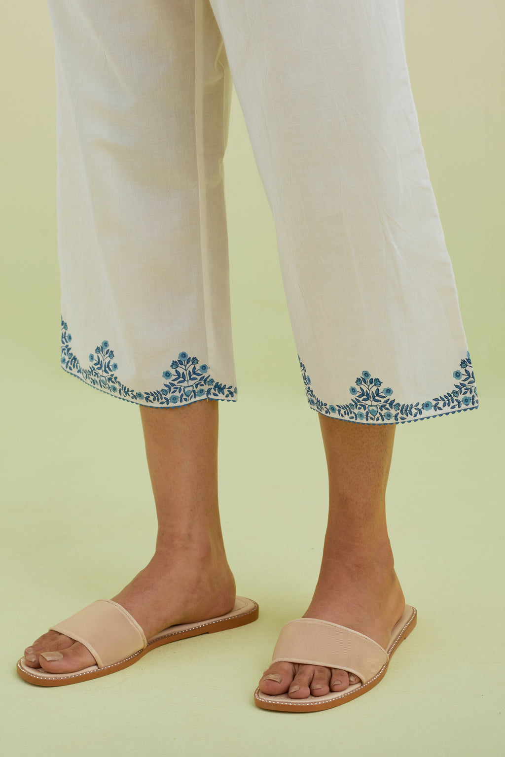 Off white straight ankle length pants with blue colored hand-block printed border at hem.