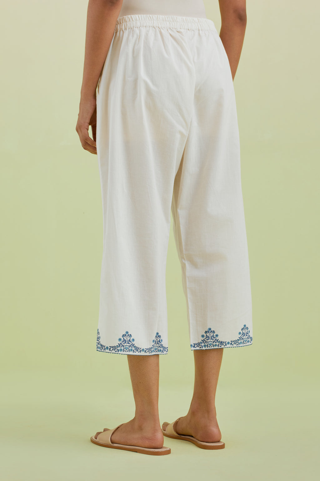 Off white straight ankle length pants with blue colored hand-block printed border at hem.