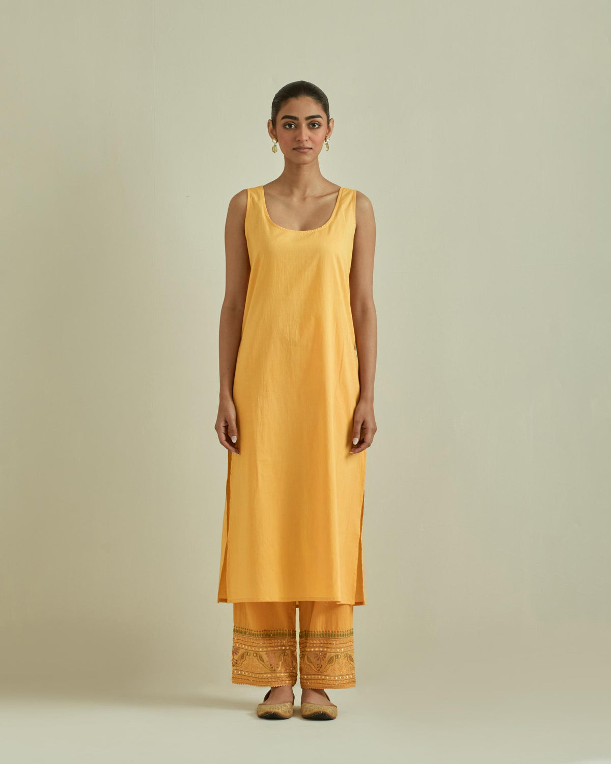Yellow cotton chanderi straight kurta set with yoke and side panels. It has allover patchwork and silk thread embroidery, highlighted with mirror, sequins, tassels and braids.