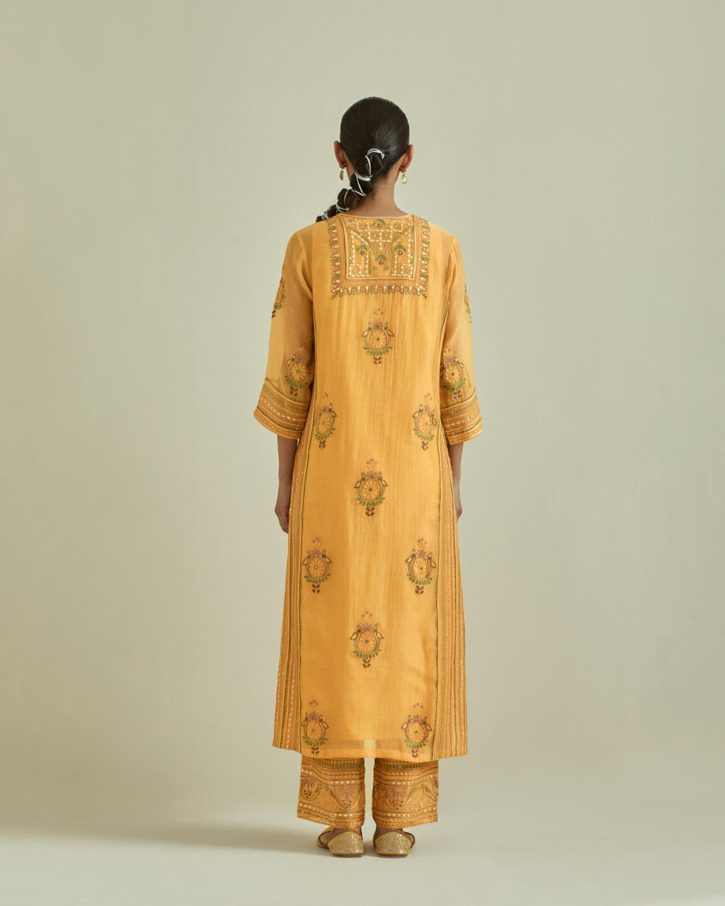 Yellow cotton chanderi straight kurta set with yoke and side panels. It has allover patchwork and silk thread embroidery, highlighted with mirror, sequins, tassels and braids.
