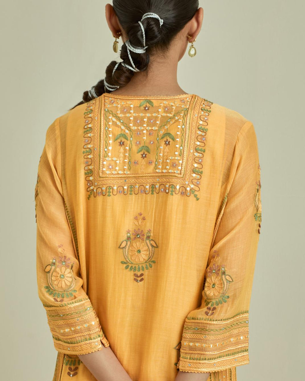 Yellow cotton chanderi straight kurta set with yoke and side panels. It has allover patchwork and silk thread embroidery, highlighted with mirror, sequins, tassels and braids.