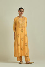 Yellow cotton chanderi straight kurta set with yoke and side panels. It has allover patchwork and silk thread embroidery, highlighted with mirror, sequins, tassels and braids.