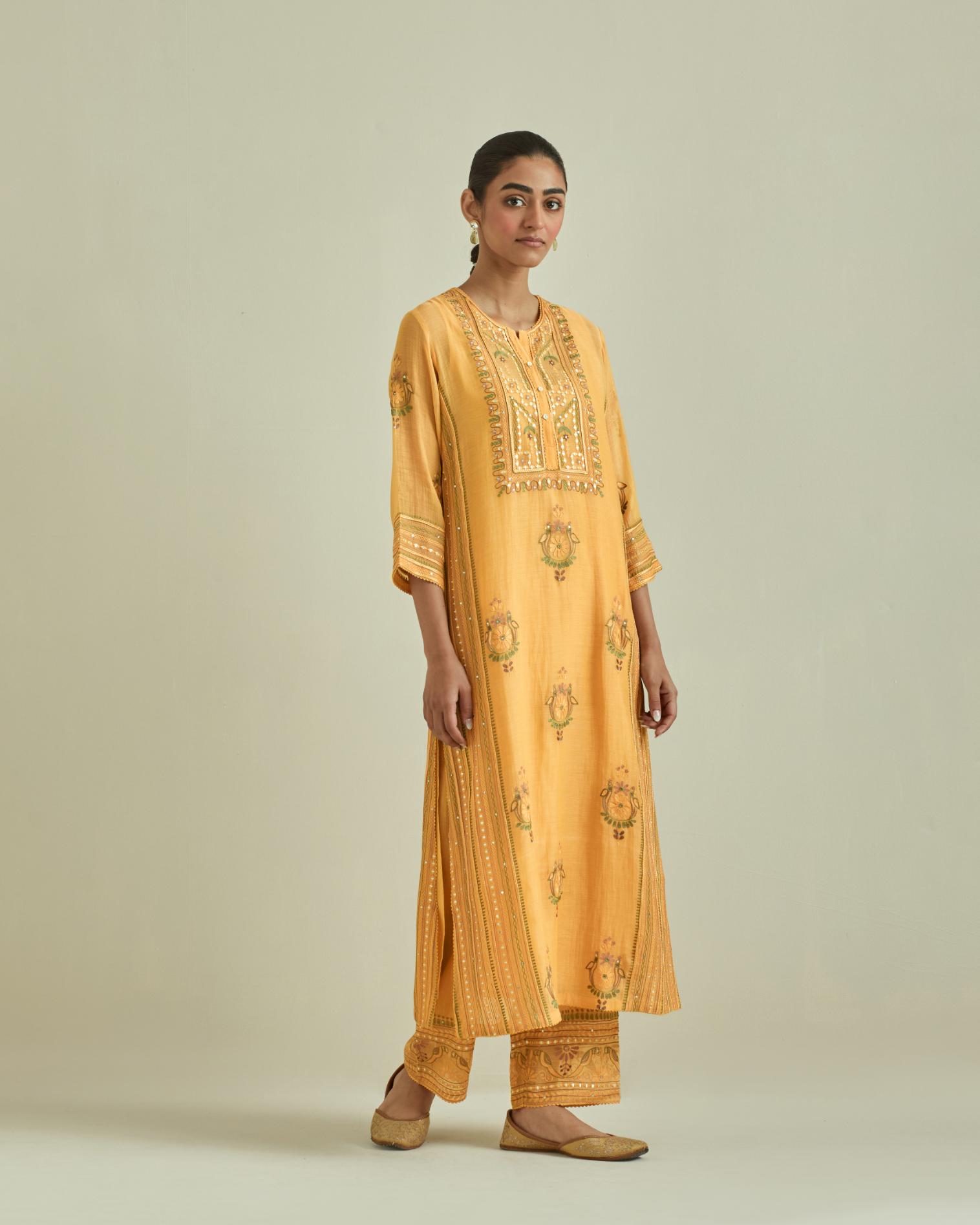 Yellow cotton chanderi straight kurta set with yoke and side panels. It has allover patchwork and silk thread embroidery, highlighted with mirror, sequins, tassels and braids.