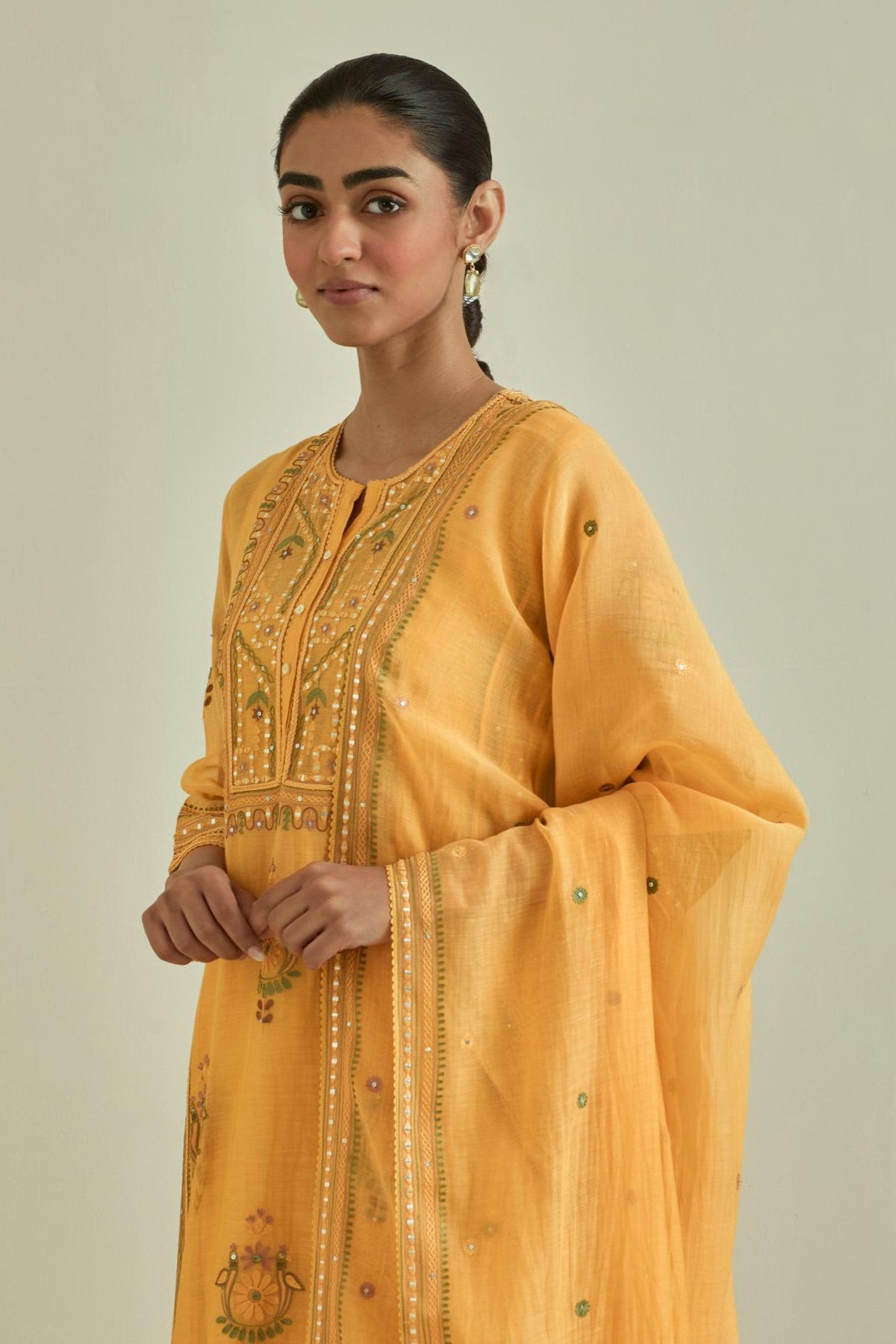 Yellow cotton chanderi dupatta with delicate silk thread embroidery, highlighted with braids, mirrors and sequins work.