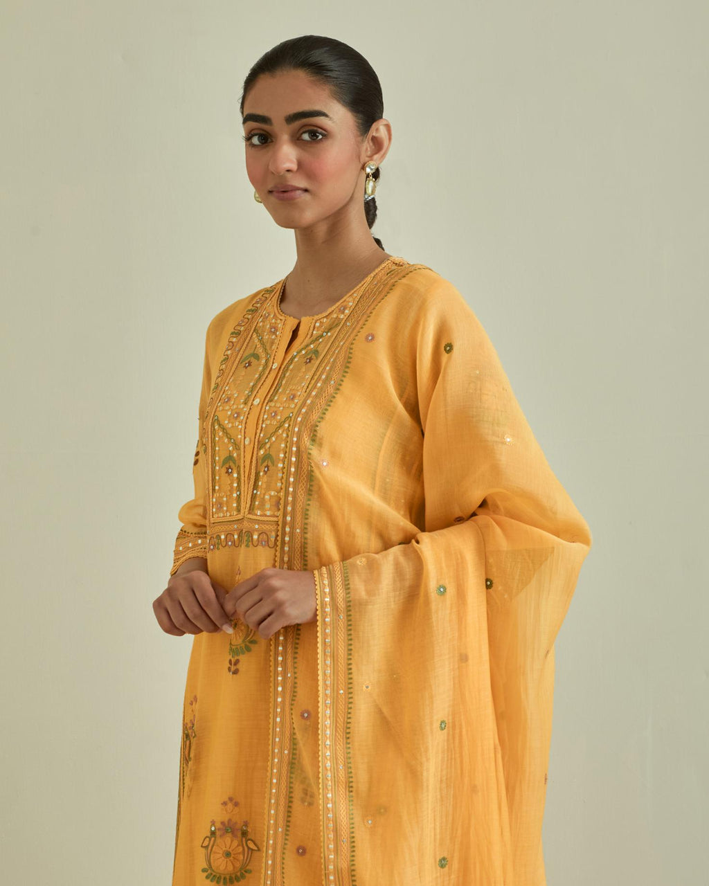 Yellow cotton chanderi dupatta with delicate silk thread embroidery, highlighted with braids, mirrors and sequins work.