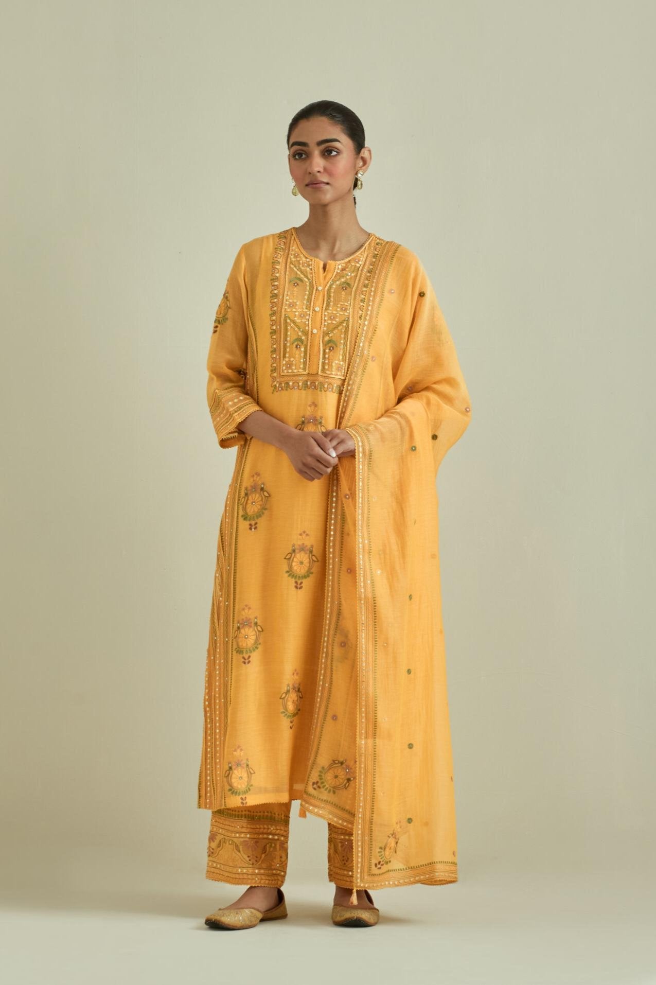 Yellow cotton chanderi straight kurta set with yoke and side panels. It has allover patchwork and silk thread embroidery, highlighted with mirror, sequins, tassels and braids.