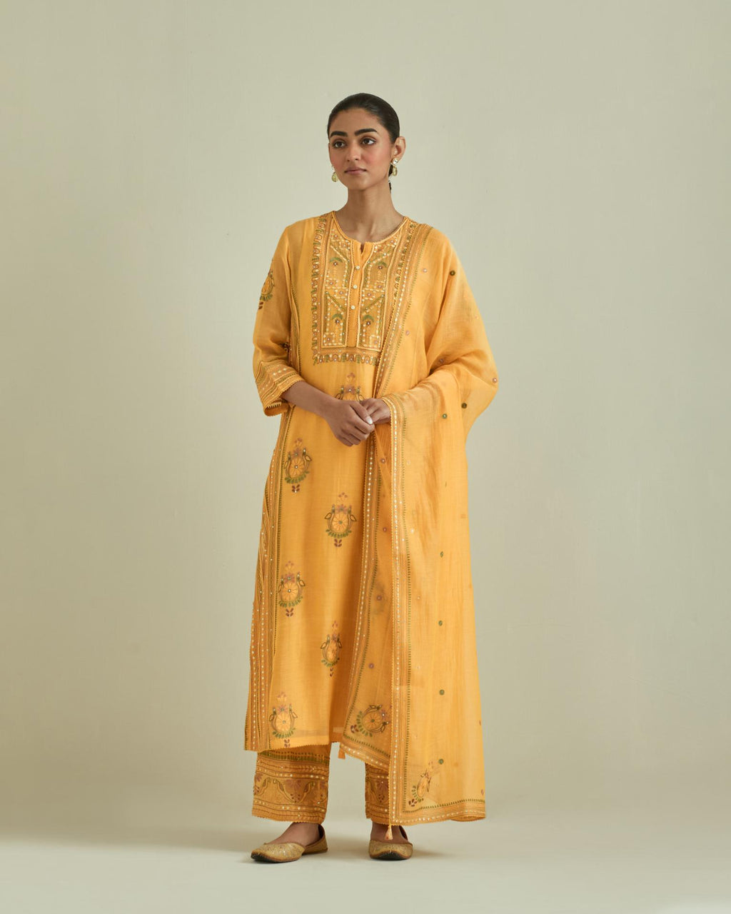 Yellow cotton chanderi straight kurta set with yoke and side panels. It has allover patchwork and silk thread embroidery, highlighted with mirror, sequins, tassels and braids.