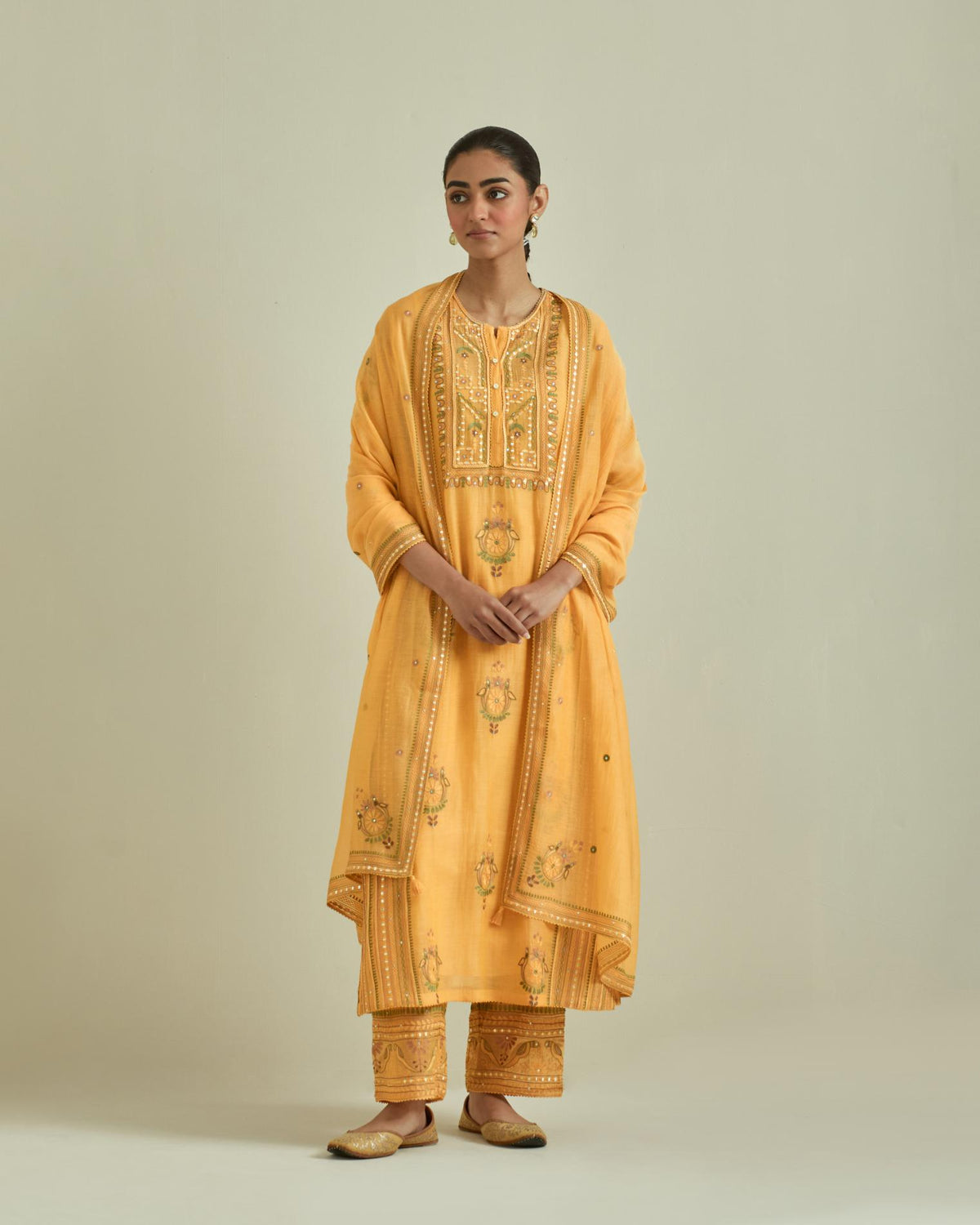 Yellow cotton chanderi straight kurta set with yoke and side panels. It has allover patchwork and silk thread embroidery, highlighted with mirror, sequins, tassels and braids.