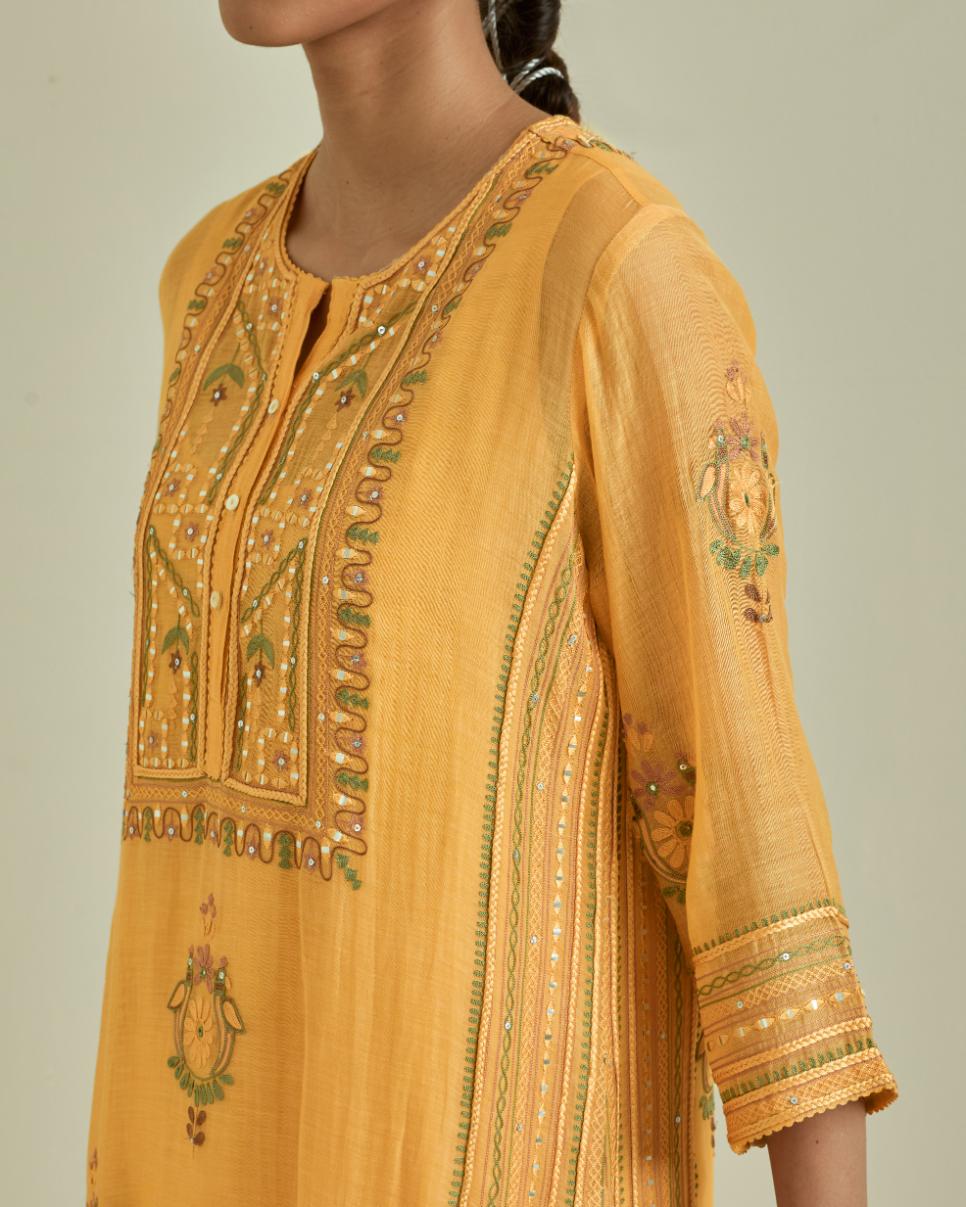 Yellow cotton chanderi straight kurta set with yoke and side panels. It has allover patchwork and silk thread embroidery, highlighted with mirror, sequins, tassels and braids.