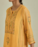 Yellow cotton chanderi straight kurta set with yoke and side panels. It has allover patchwork and silk thread embroidery, highlighted with mirror, sequins, tassels and braids.