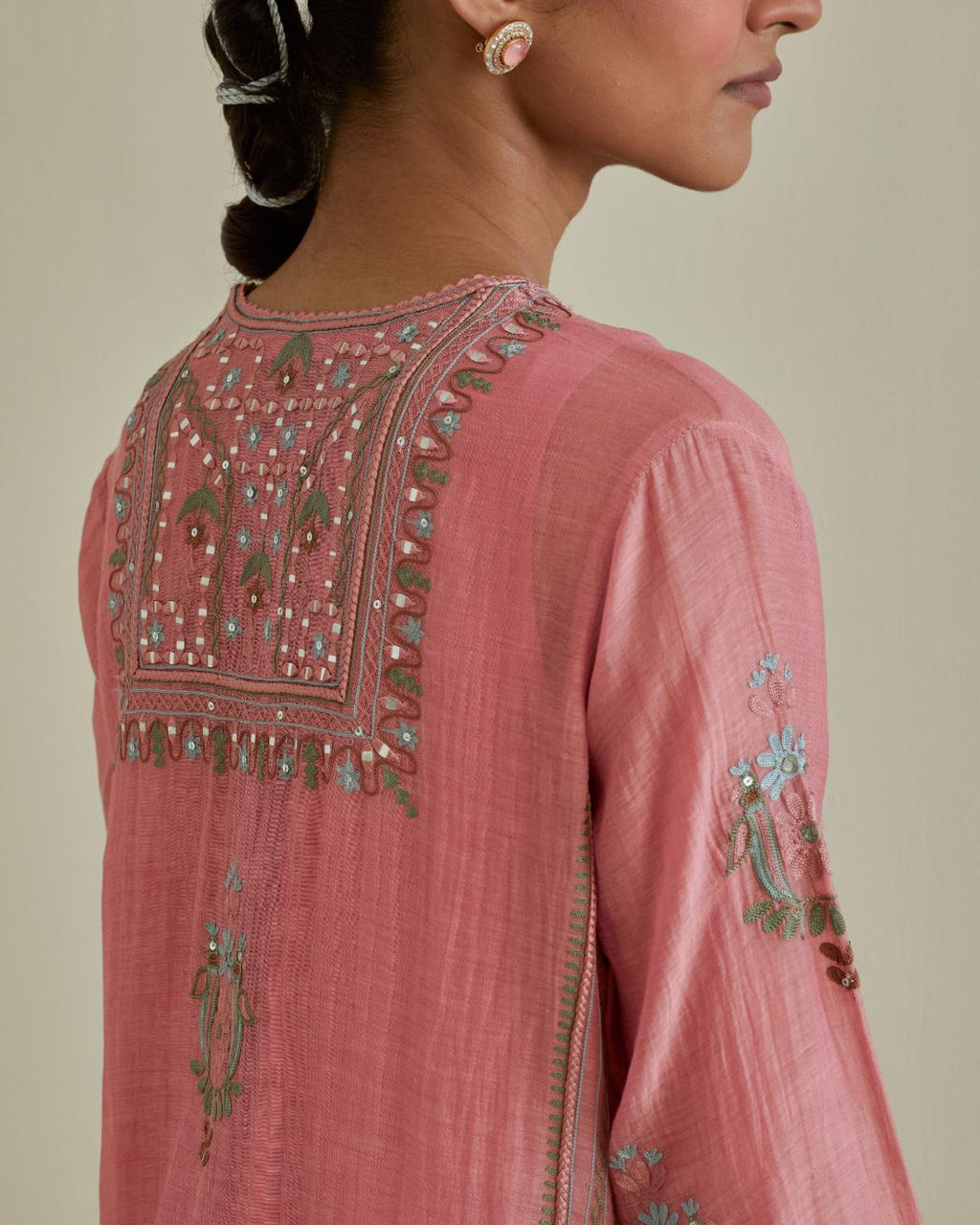 Pink cotton chanderi straight kurta set with yoke and side panels. It has allover patchwork and silk thread embroidery, highlighted with mirror, sequins, tassels and braids.