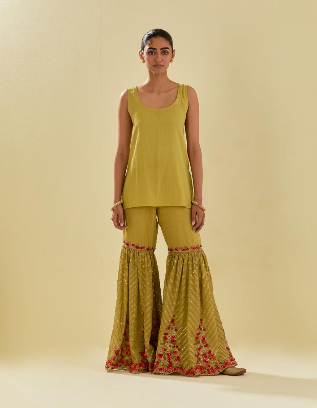 Yellow tissue chanderi short kurta set with round neck and slit in the front and all-over hand cut silk flower embroidery.