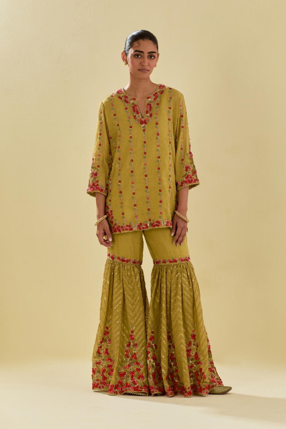 Yellow tissue chanderi short kurta set with round neck and slit in the front and all-over hand cut silk flower embroidery.