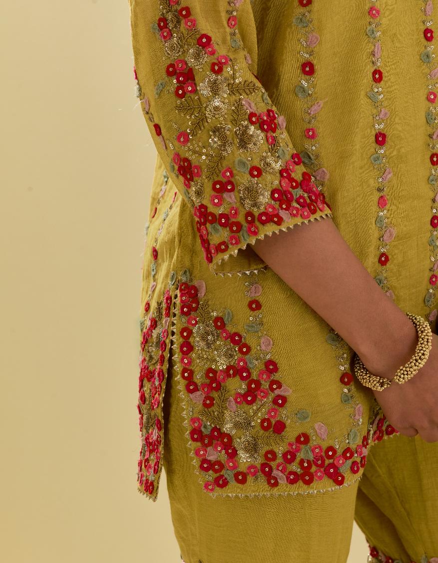 Yellow tissue chanderi short kurta set with round neck and slit in the front and all-over hand cut silk flower embroidery.