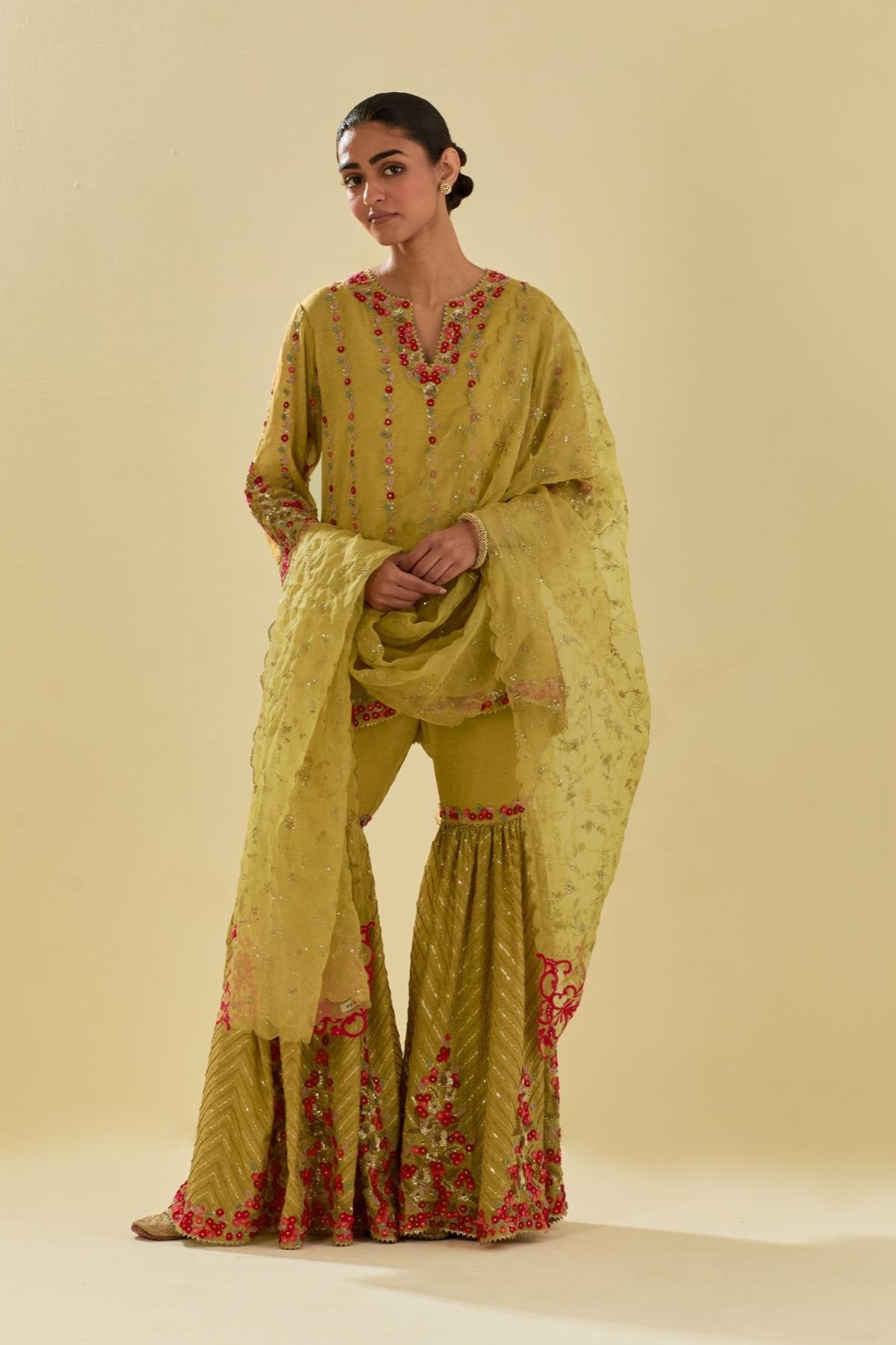 Yellow tissue chanderi short kurta set with round neck and slit in the front and all-over hand cut silk flower embroidery.