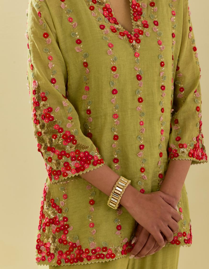 Green tissue chanderi short kurta set with round neck and slit in the front and all-over hand cut silk flower embroidery.